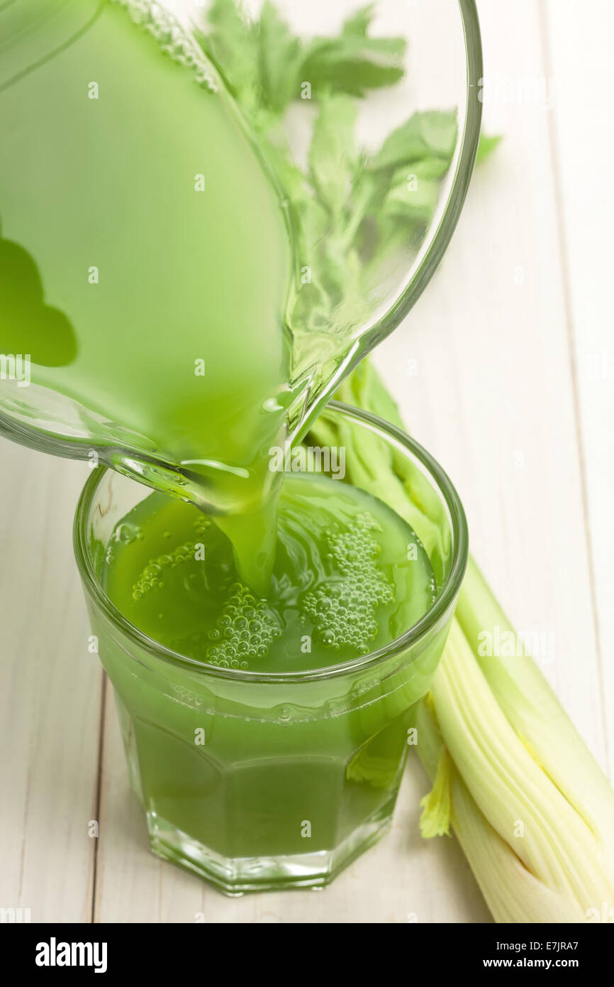 Verde succo vegetale con il sedano in legno bianco Foto Stock