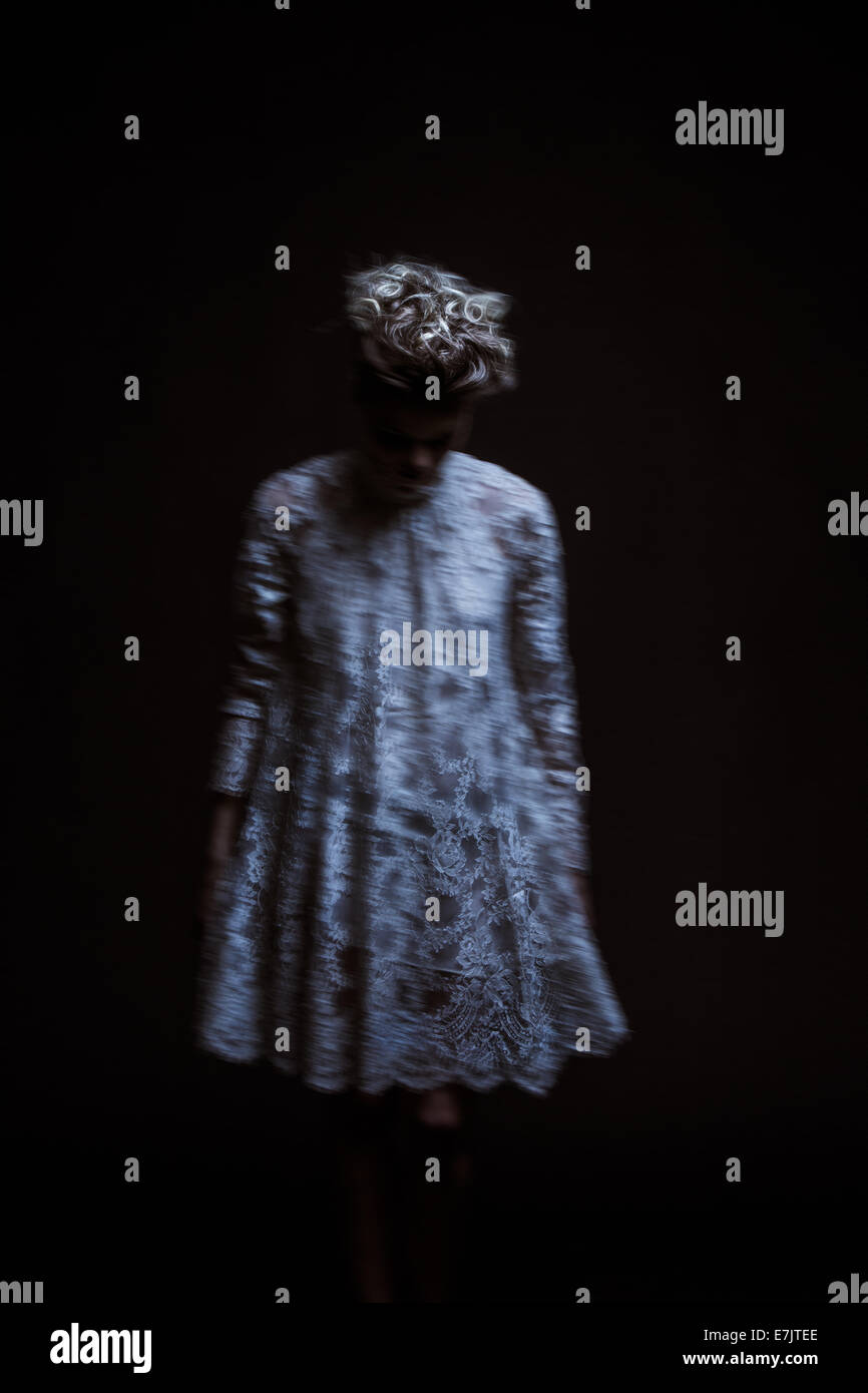 Un fantasma della donna in piedi in una stanza buia. Foto Stock