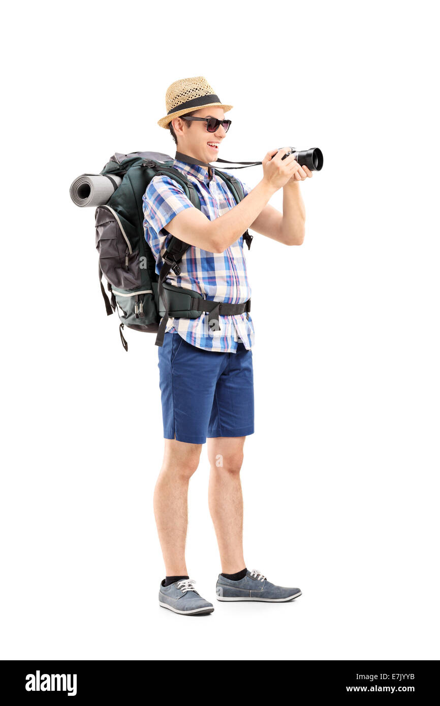 A piena lunghezza Ritratto di un turista maschio di scattare una foto con una fotocamera isolati su sfondo bianco Foto Stock