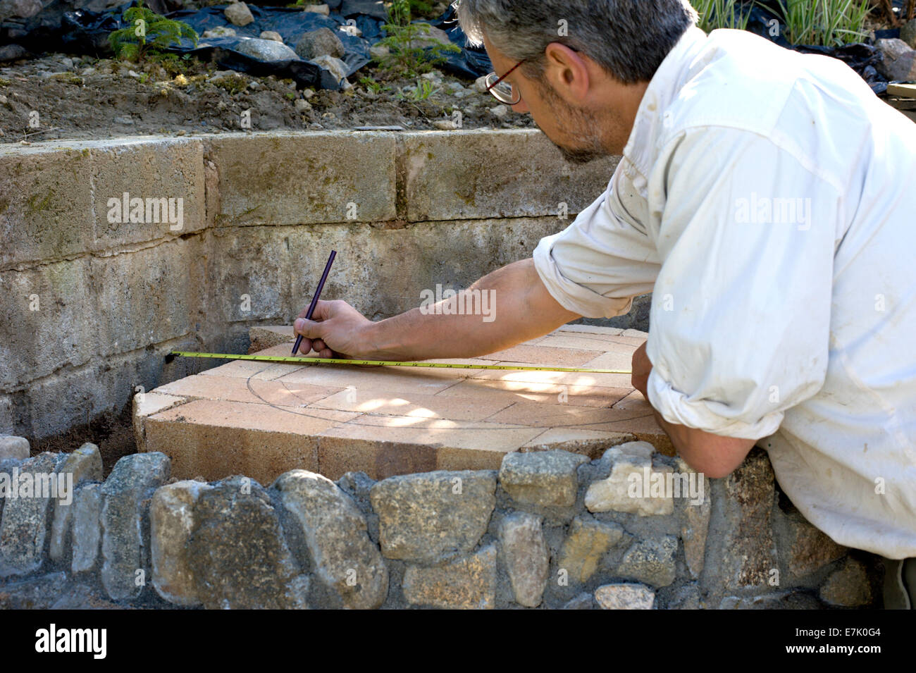 Cob di argilla terra forno progetto. La base è fatto e lo strato di sabbia di livello è stato fatto adesso per i mattoni refrattari Foto Stock