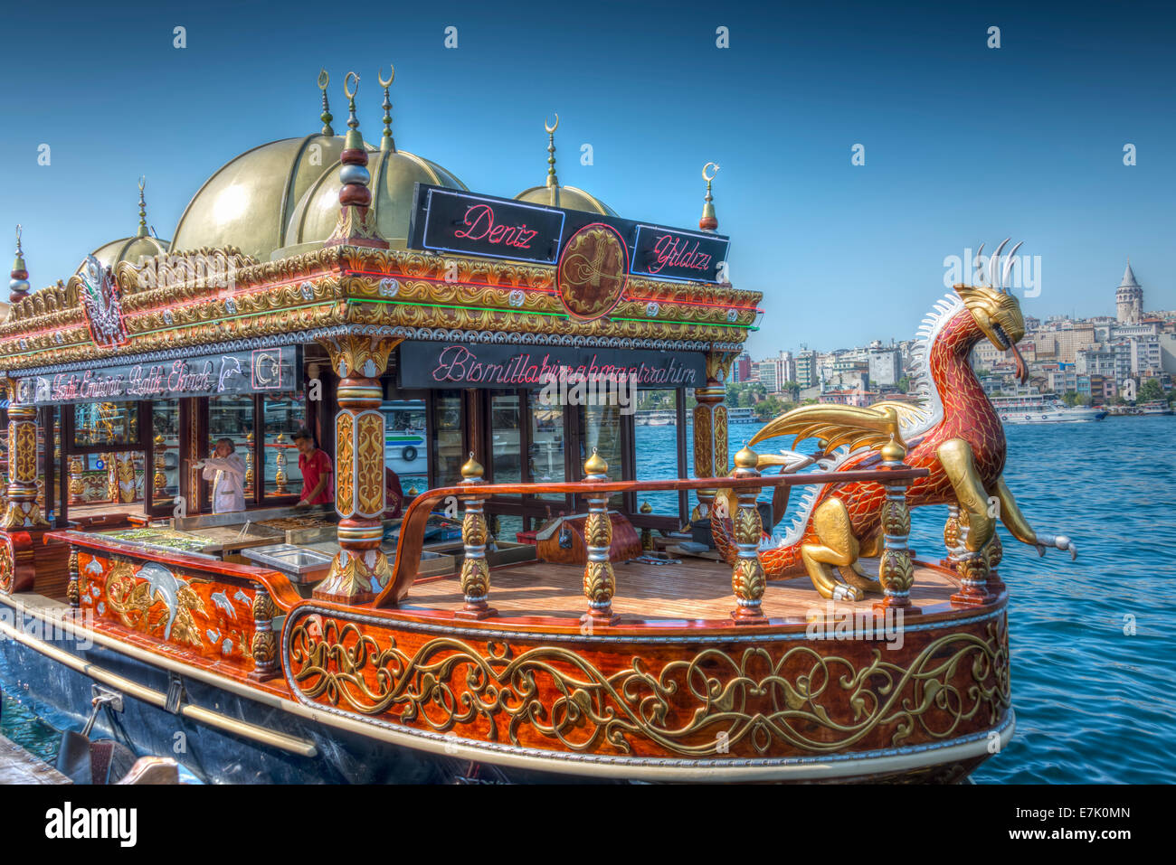 Un balık-ekmek barca serve pesce spiedini accanto al Ponte di Galata a Istanbul Foto Stock