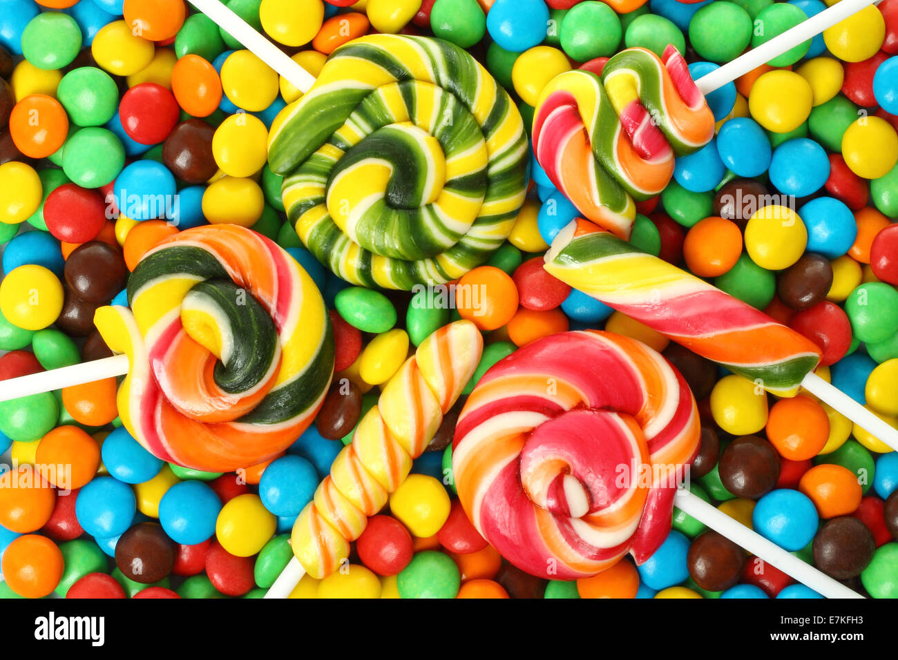 Spirale colorata lollipop con cioccolato rivestito sullo sfondo di caramella Foto Stock