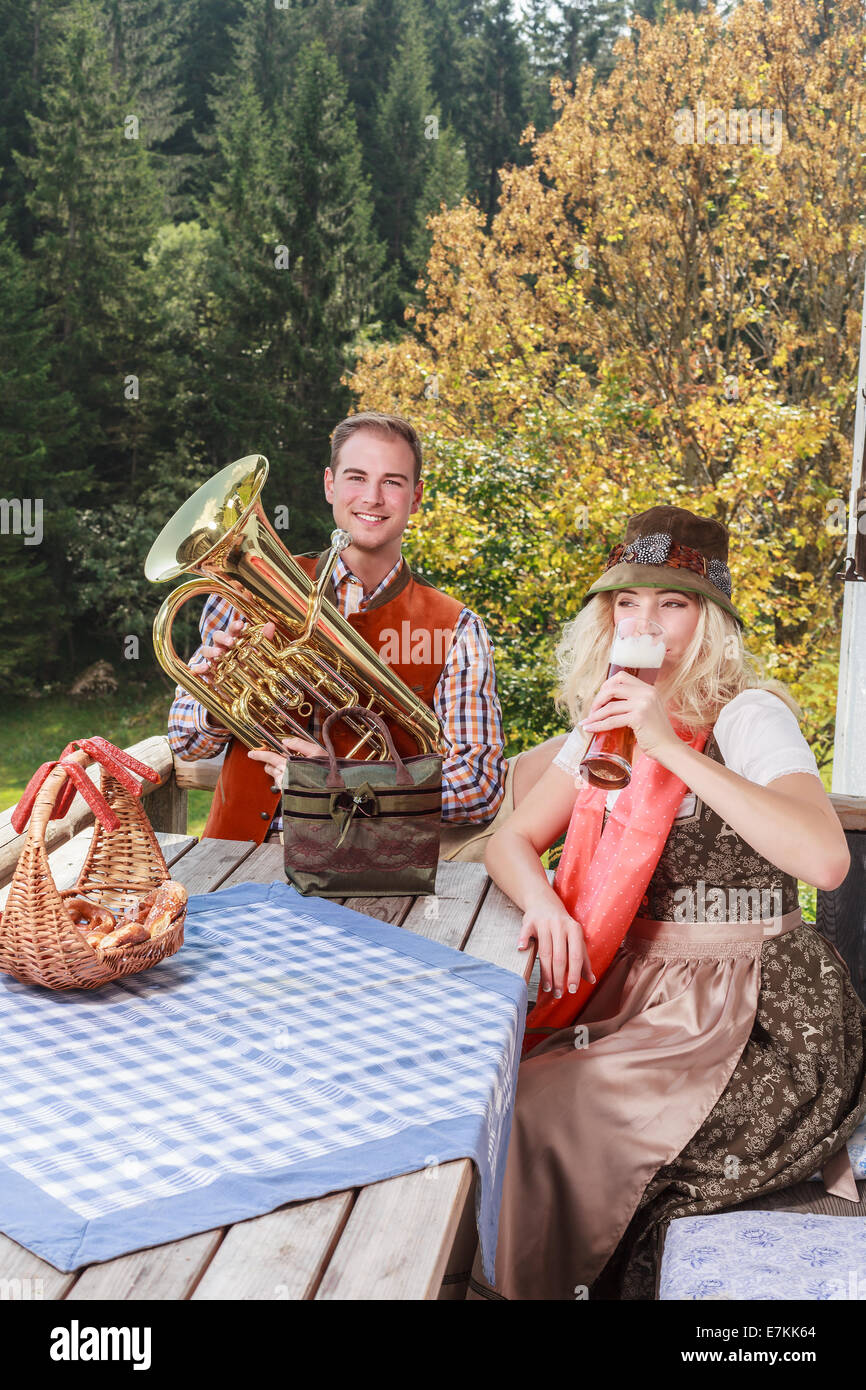 Coppia giovane in tradizionali abiti bavarese godetevi il vostro tempo libero in comune Foto Stock