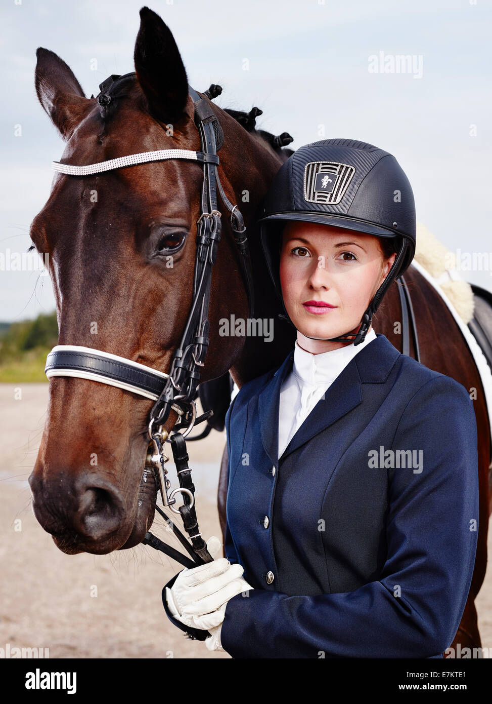 Marrone a cavallo e bella donna che indossa equitazione abbigliamento Foto Stock