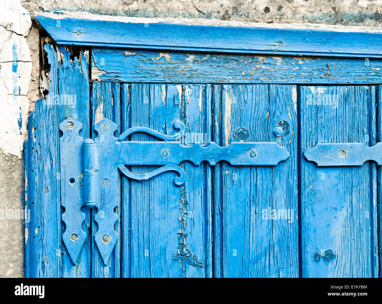 Angolo di un vecchio blu porta in legno con una cerniera decorativa Foto Stock