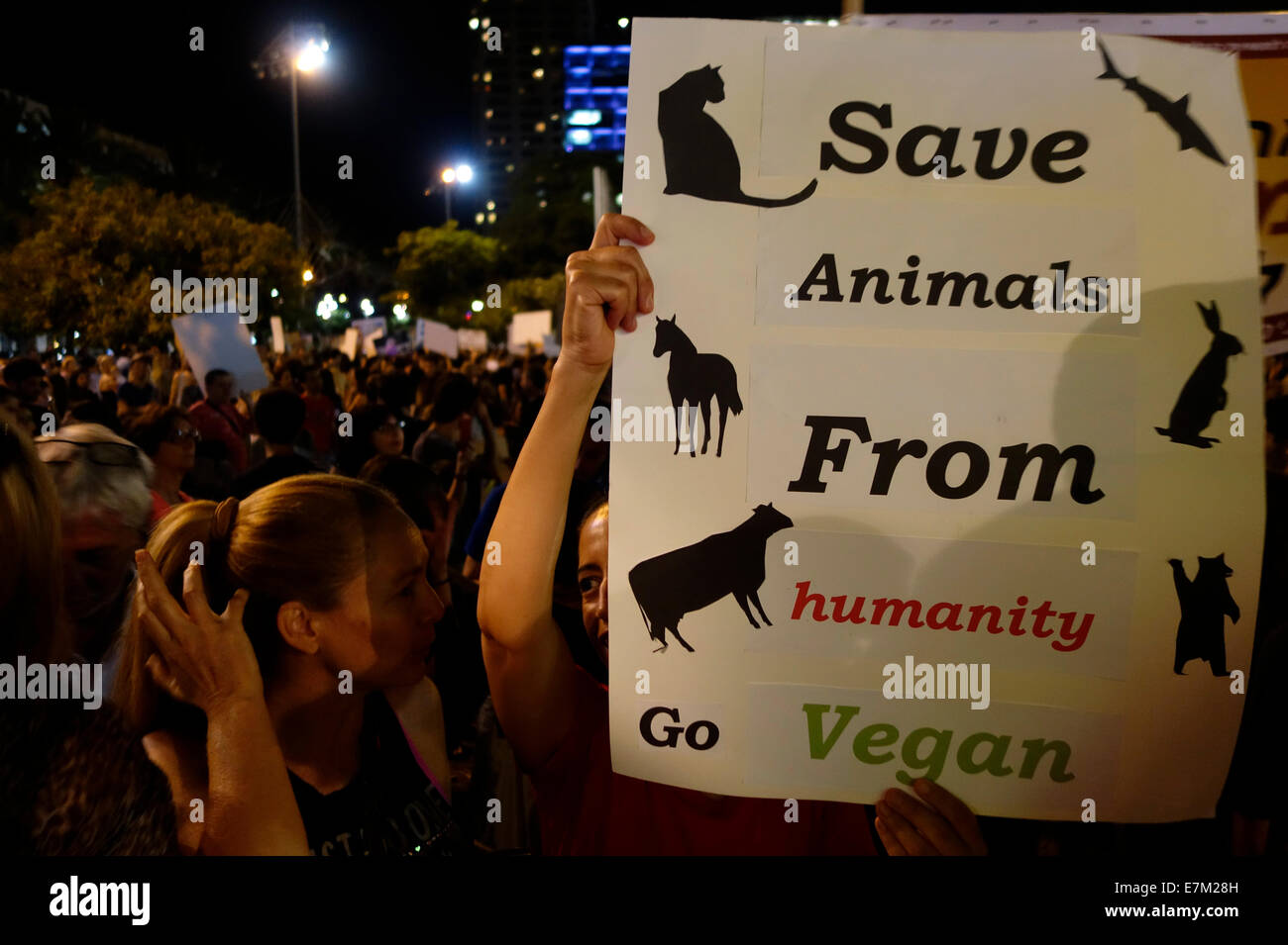 Un dimostratore ha un cartello con la scritta "Save Animals from Humanity Go Vegan" durante un raduno per i diritti degli animali a Tel Aviv Israele il 20 settembre 2014. I manifestanti tengono in su i segni che ingannano i trasporti di bestiame ad Israele per la macellazione e la sperimentazione sugli animali. Foto Stock
