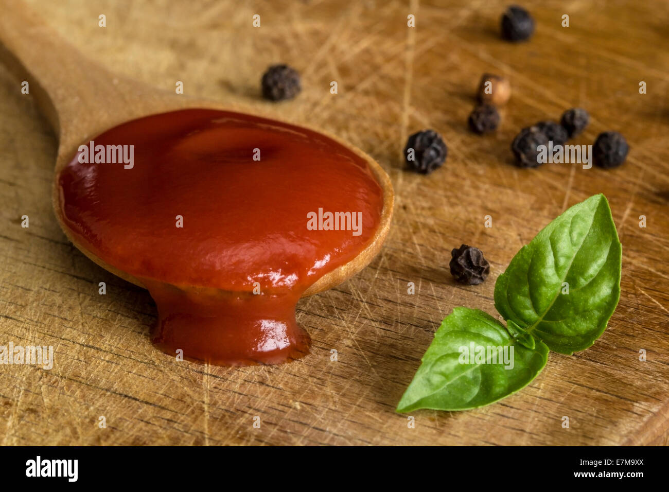 Salsa di pomodoro, basilico pepe su uno sfondo di legno Foto Stock
