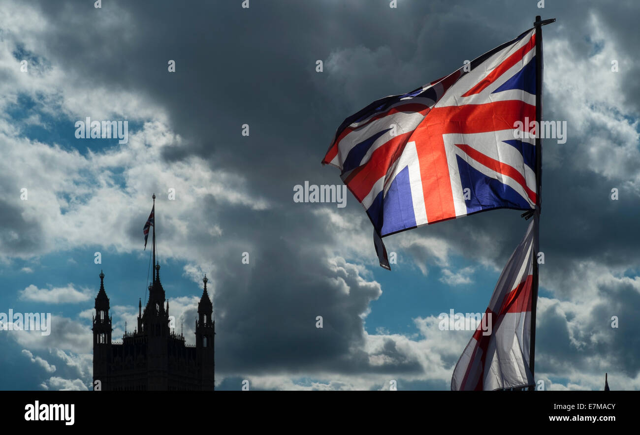 La Union Jack e bandiera di St George sorvolare un souvenir in stallo sul Westminster Bridge. Le case del Parlamento in background Foto Stock