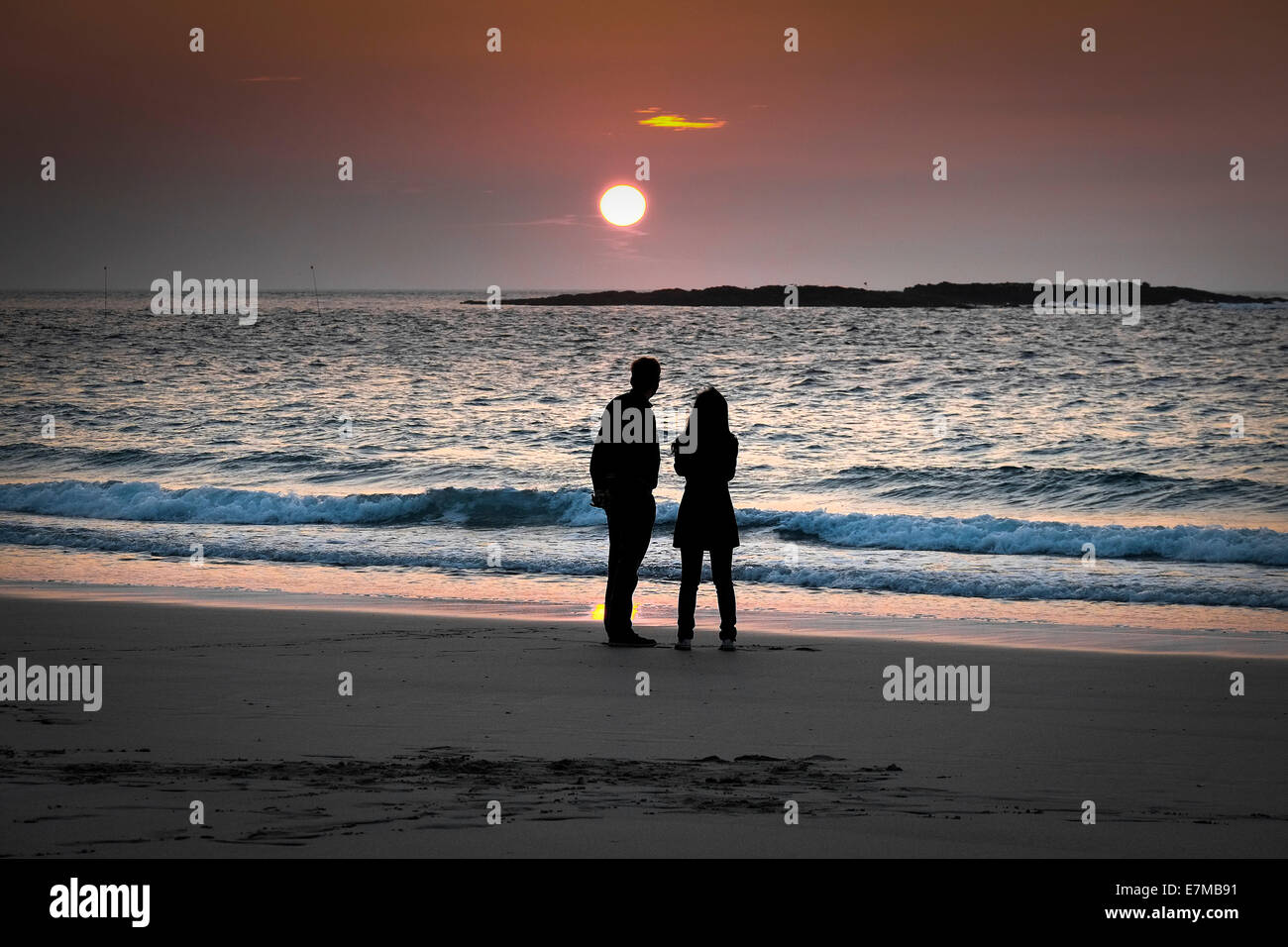 La silhouette di un paio di piedi su Sennen Cove Beach al tramonto. Foto Stock