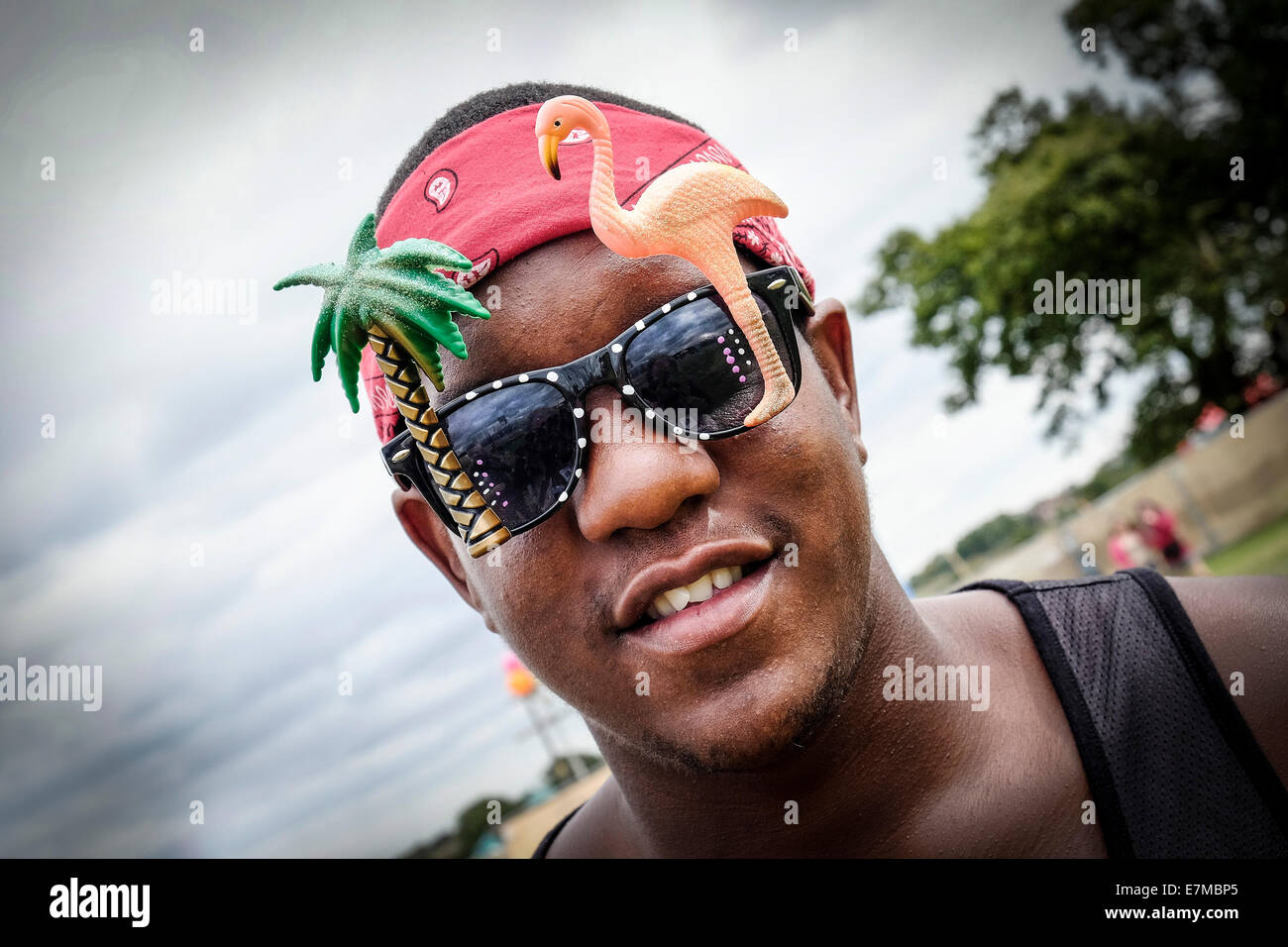 Un festivalgoer indossando occhiali da sole di novità al Festival Brownstock in Essex. Foto Stock