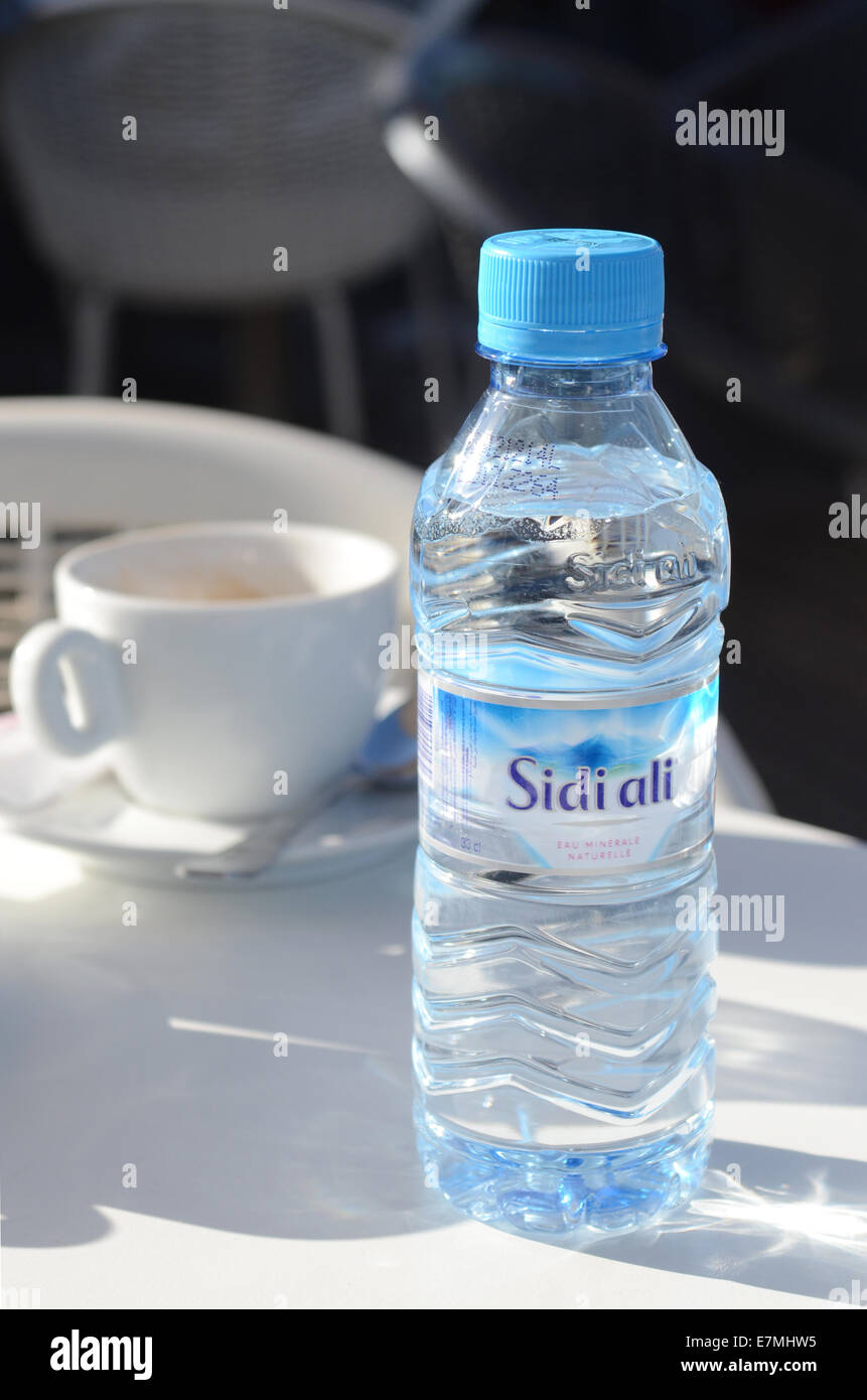 Sidi Ali la bottiglia di acqua minerale con tazza di caffè su un tavolo del bar Foto Stock