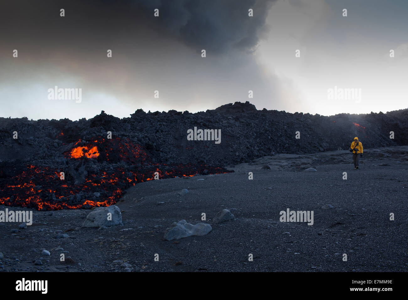 Eruzione del vulcano, Holuhraun, nel nord-est dell'Islanda, uomo a camminare molto strettamente oltre la lava incandescente Foto Stock