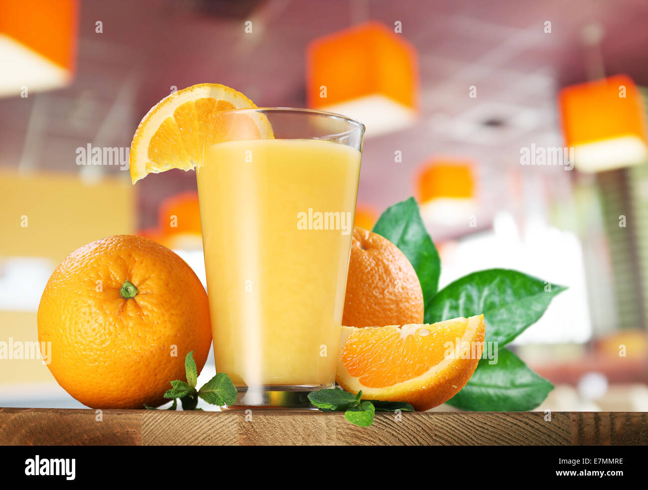 Frutti di colore arancione e un bicchiere di succo di arancia sul tavolo di legno. Foto Stock