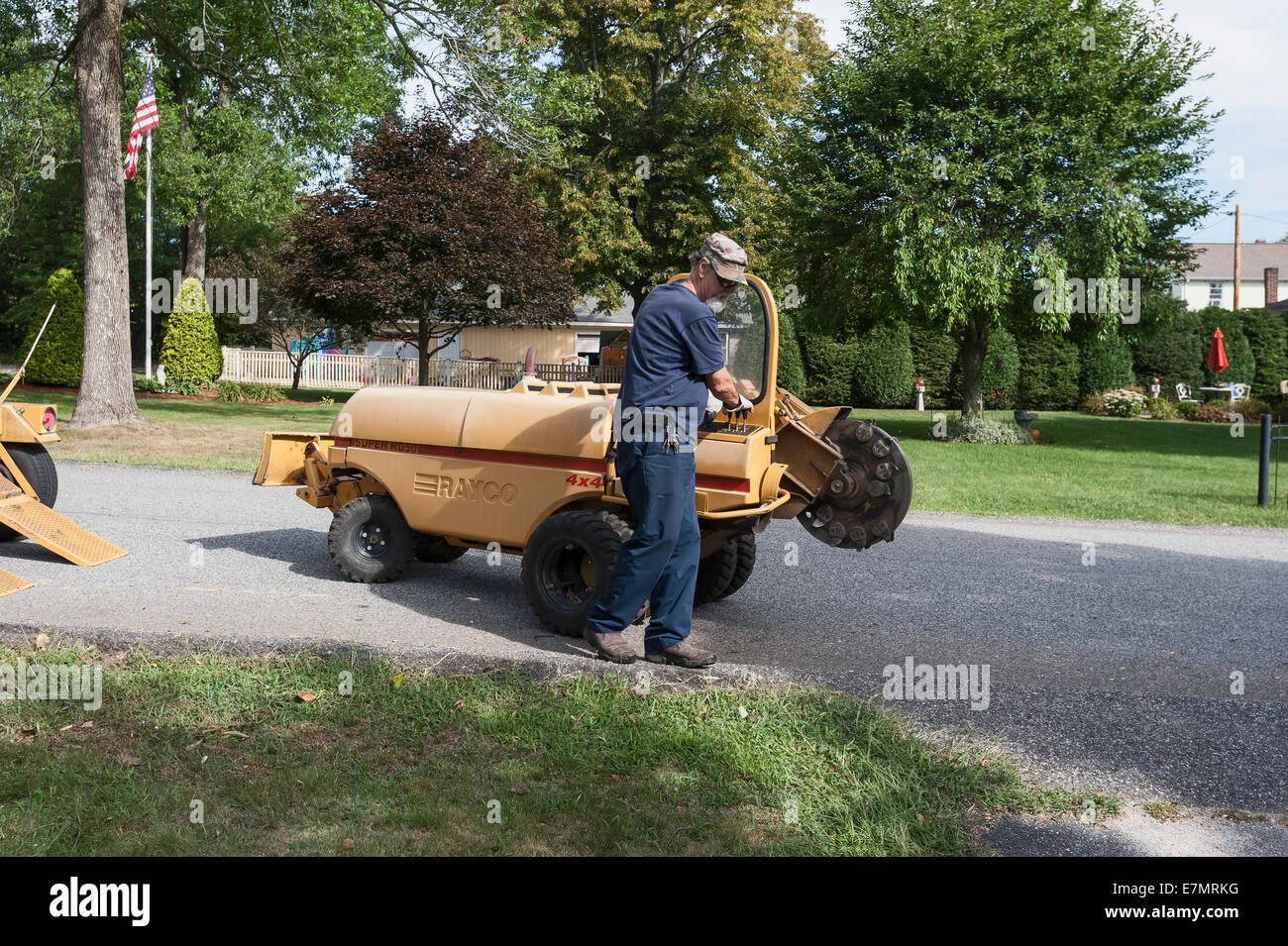 Un uomo con un modello di Rayco Super RG50 4X4 moncone smerigliatrice per rimuovere un ceppo di albero in Rhode Island USA Foto Stock