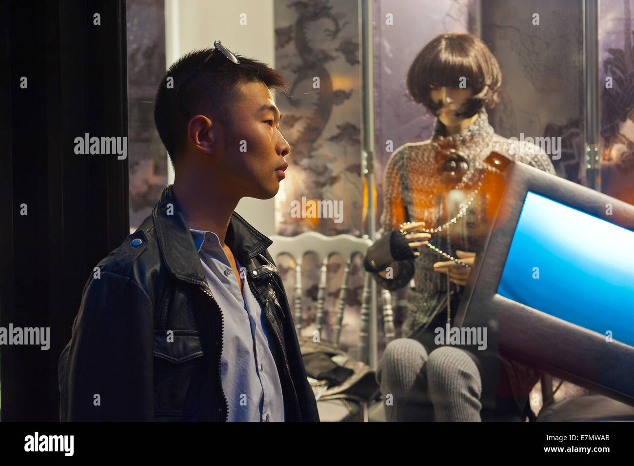 Parigi, Francia, giovane uomo cinese al di fuori del negozio di lusso di window shopping, notte Foto Stock