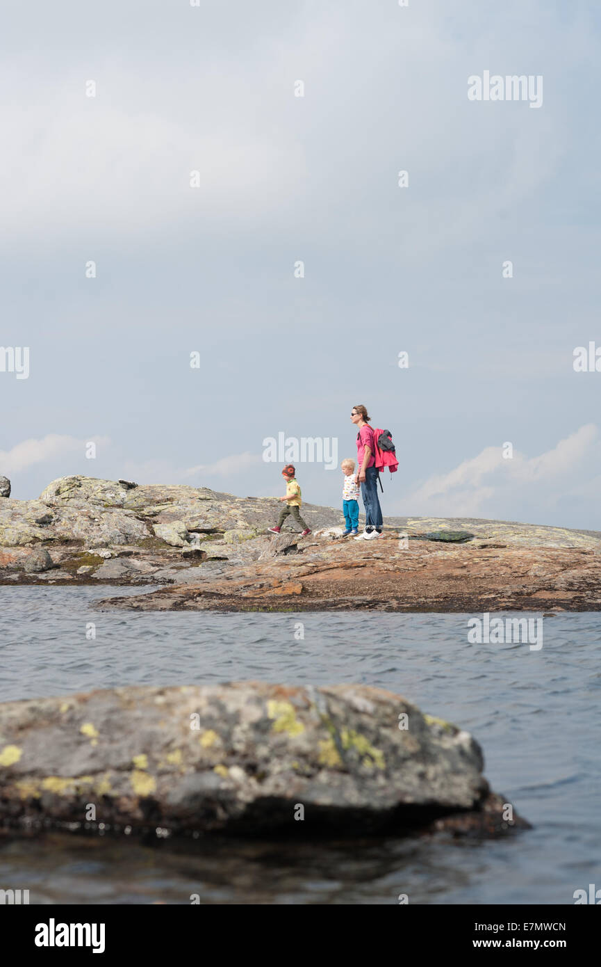 La mamma con bambini sky a passi da un lago di montagna vicino alla sommità del monte Åreskutan, Åre, Svezia Foto Stock