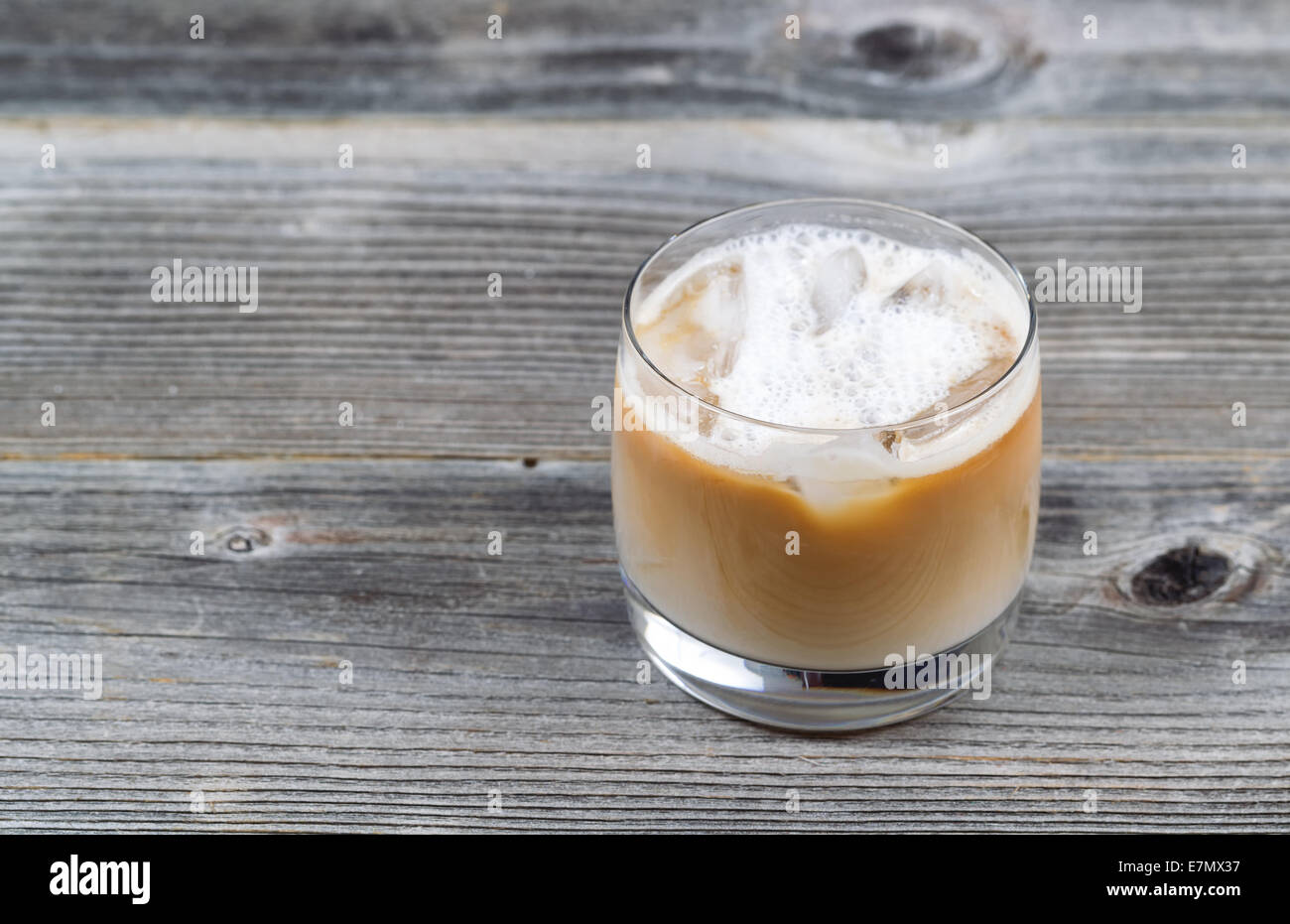 Preparata di fresco caffè ghiacciato con la crema di latte in vetro su legno rustico Foto Stock