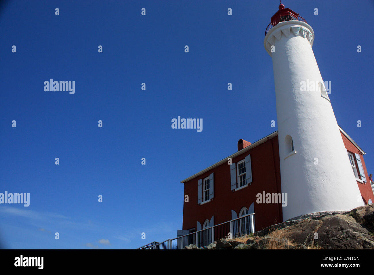 Il bianco e il rosso faro contro estate cielo blu chiaro Foto Stock