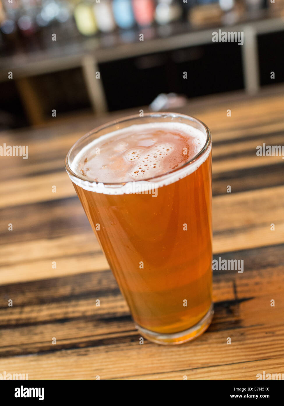 Una pinta di birra seduti su un bar Foto Stock