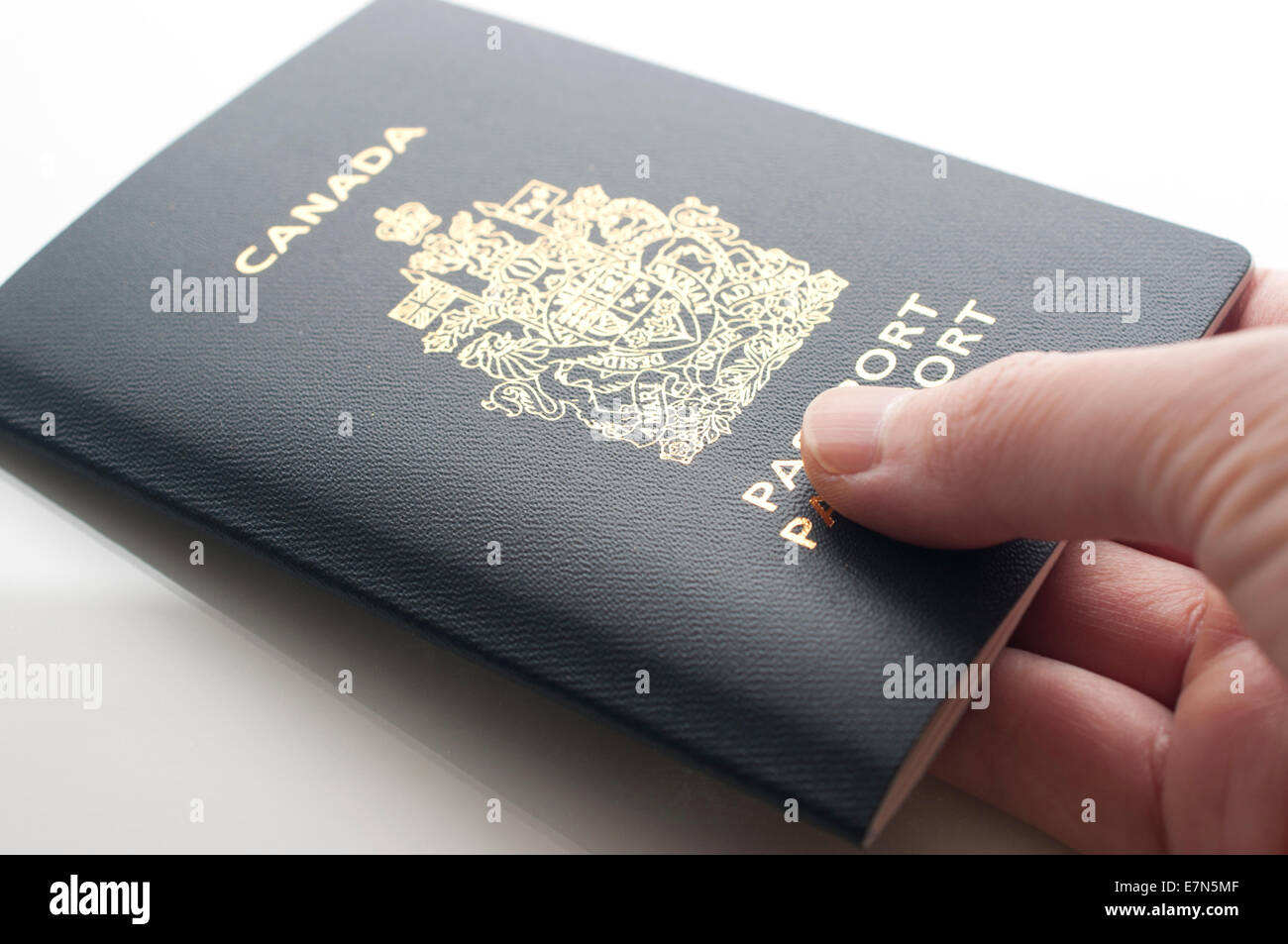 Una mano che tiene un passaporto canadese Foto Stock