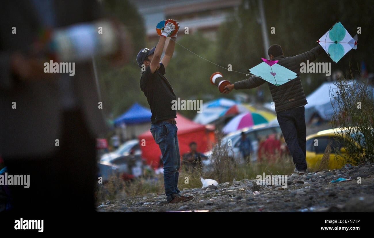 Lhasa, la Cina della regione autonoma del Tibet. Xix Sep, 2014. La gente volare Kites a Lhasa, capitale del sud-ovest della Cina di regione autonoma del Tibet, Sett. 19, 2014. Gli amanti del Kite a Lhasa hanno una tradizione di "lotta degli aquiloni sulla banca del fiume di Lhasa da agosto a ottobre di ogni anno. Cercando di aquiloni pilota in combattimento aereo, i partecipanti devono fare uno sforzo per battere o disattivare un avversario di kite in qualche modo. "Kite lotta' a Lhasa è stato elencato come la Cina nazionale della cultura immateriale patrimonio nel 2006. © Purbu Zhaxi/Xinhua/Alamy Live News Foto Stock