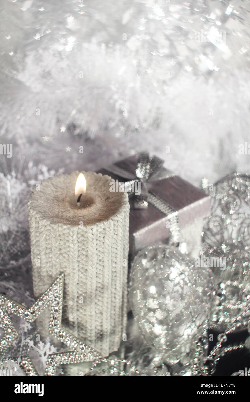 Bella argento lucido decorazioni di Natale e la candela che brucia Foto Stock