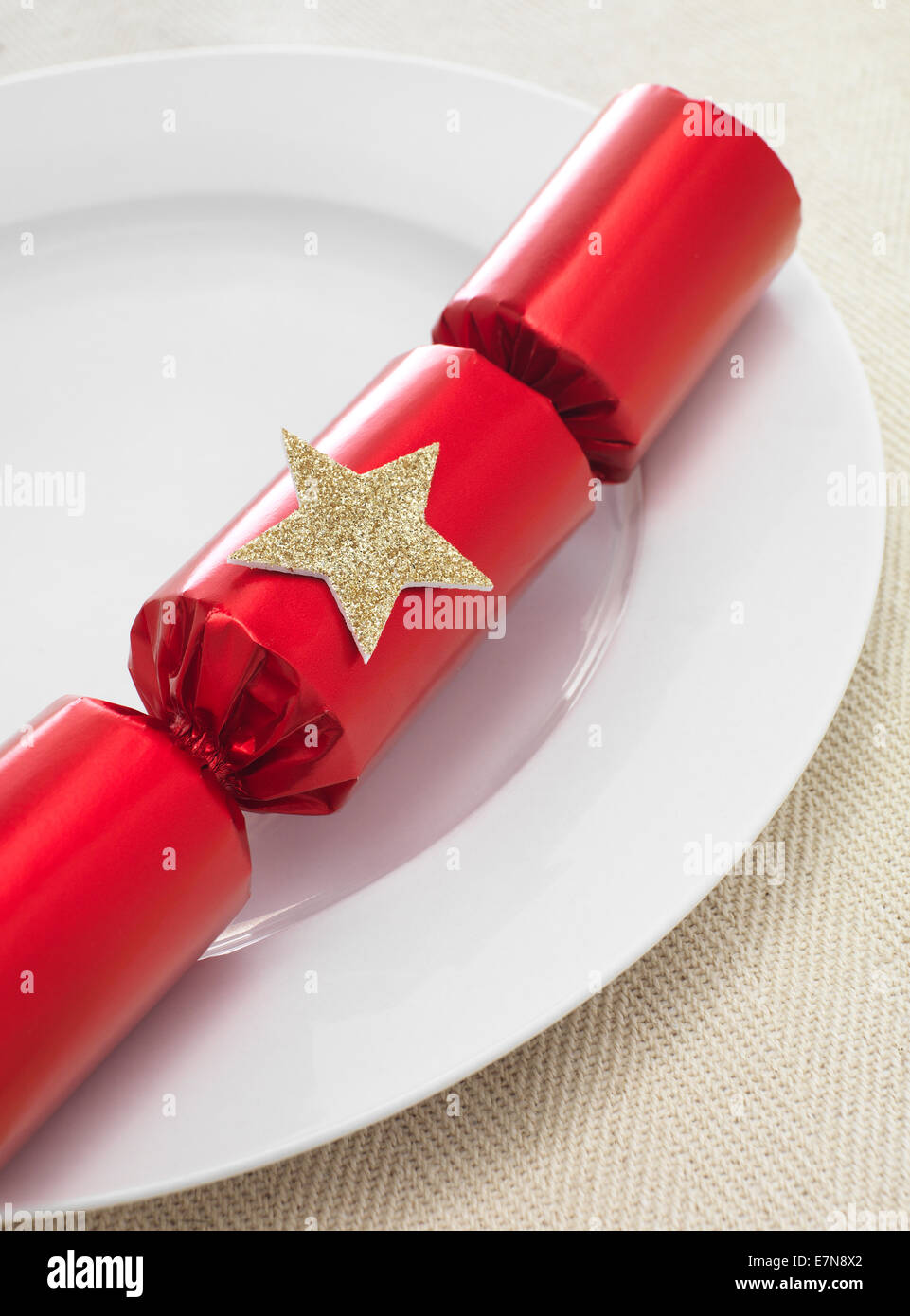 Christmas Cracker su una piastra per cena Foto Stock