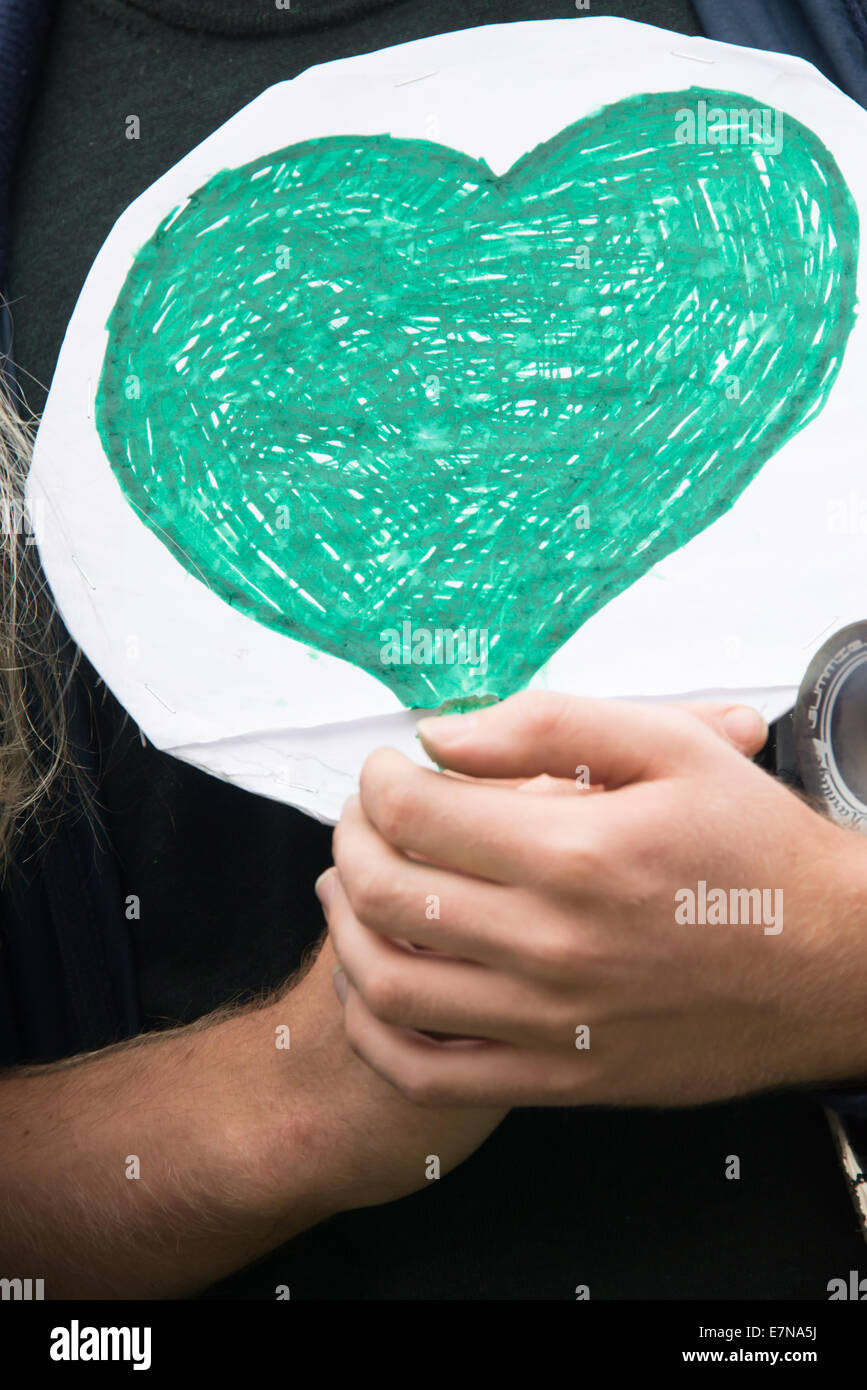 Oslo, Norvegia. Xxi Sep, 2014. Un giovane uomo porta un cuore verde come migliaia marzo attraverso il centro di Oslo, Norvegia, a sostegno di un'azione sul cambiamento climatico globale, 21 settembre 2014. Secondo gli organizzatori di "Il popolo del clima marzo", la dimostrazione di Oslo è stato uno dei 2,808 solidarietà eventi in 166 paesi, che essi rivendicazione era "il clima più grande marzo nella storia". Credito: Ryan Rodrick Beiler Alamy/Live News Foto Stock
