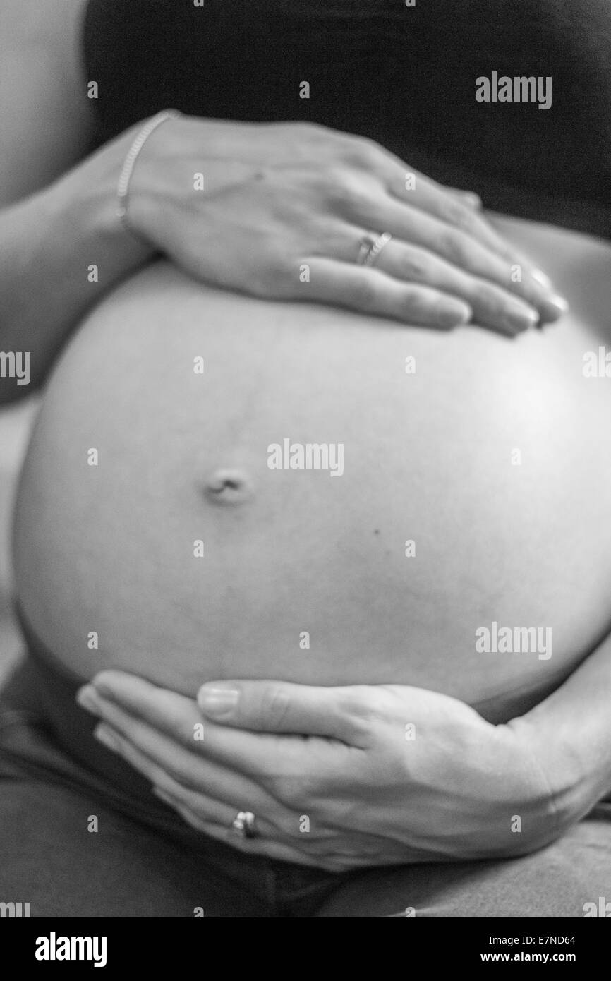 Donna incinta di contenimento ventre Foto Stock