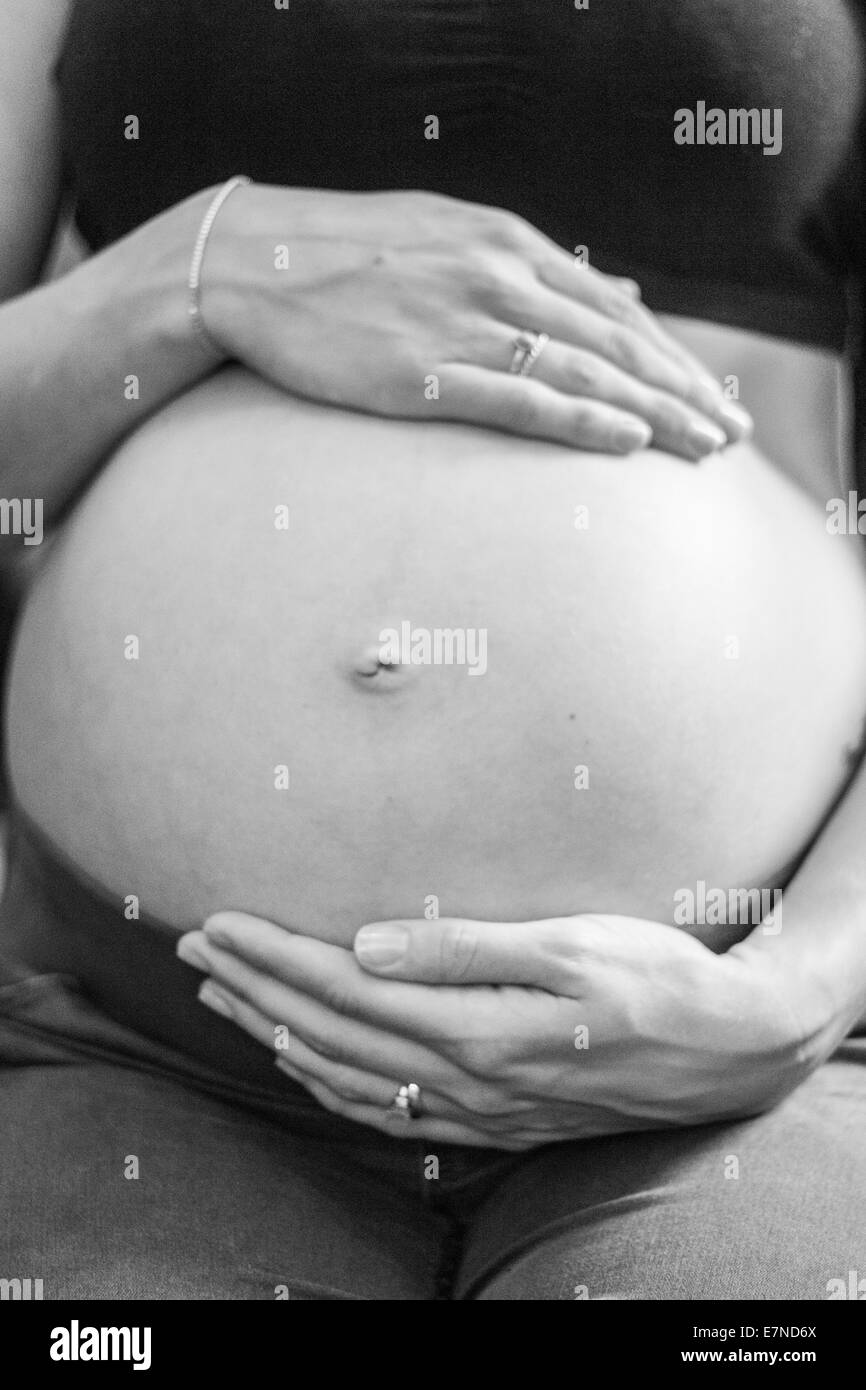 Donna incinta di contenimento ventre Foto Stock