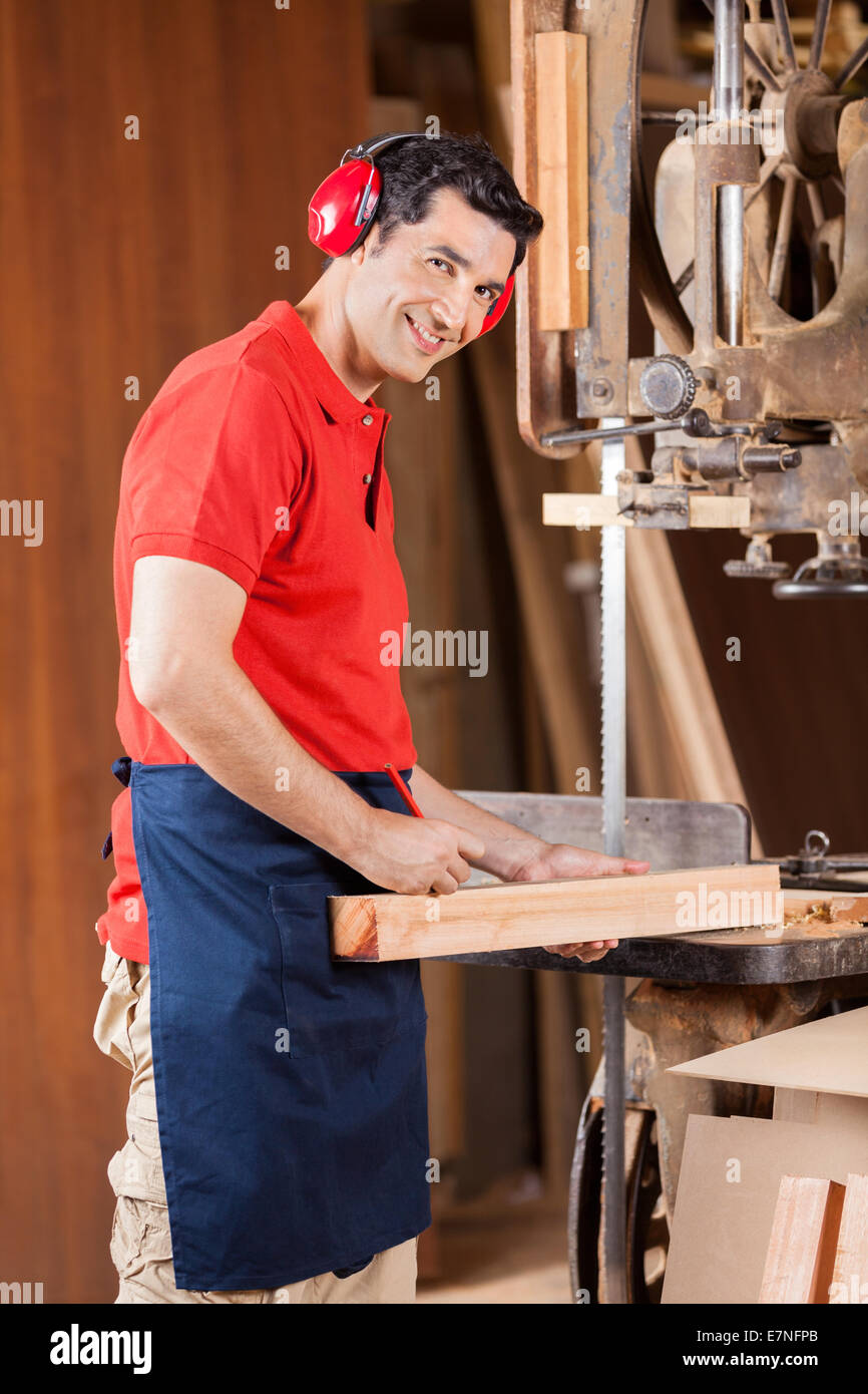 Carpenter la marcatura su legno con la matita dalla segatrice a nastro Foto Stock