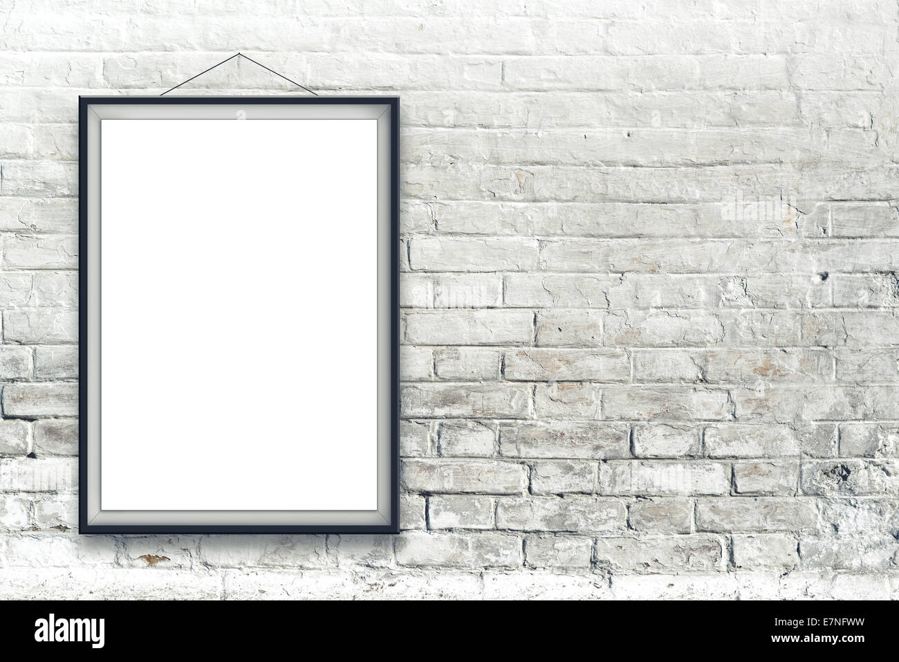 Vuoto verniciatura verticale poster nel riquadro nero appesa su bianco muro di mattoni. Pittura proporzioni corrispondono International Paper formato A Foto Stock