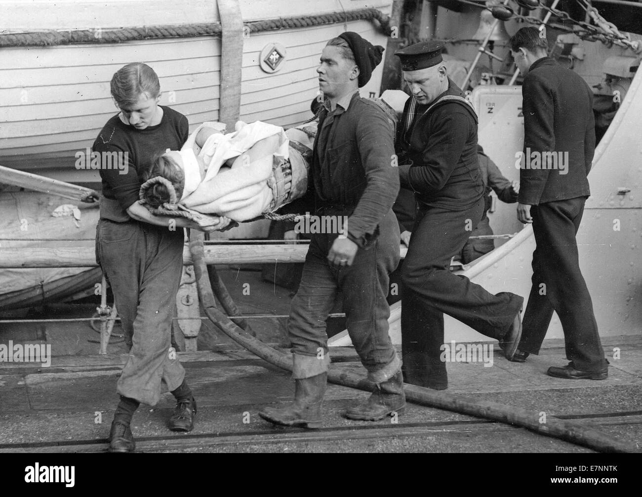 Royal Navy equipaggio portare a terra un ferito marinaio tedesco Foto Stock