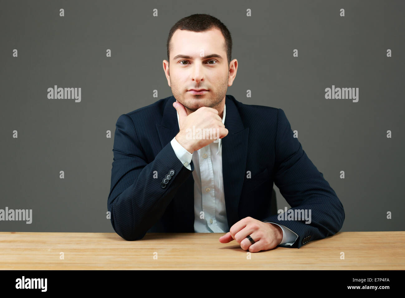 Ritratto di imprenditore gravi seduti a tavola Foto Stock