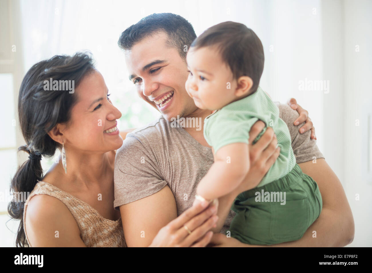 Famiglia con bambino figlio (6-11 mesi) in camera da letto Foto Stock