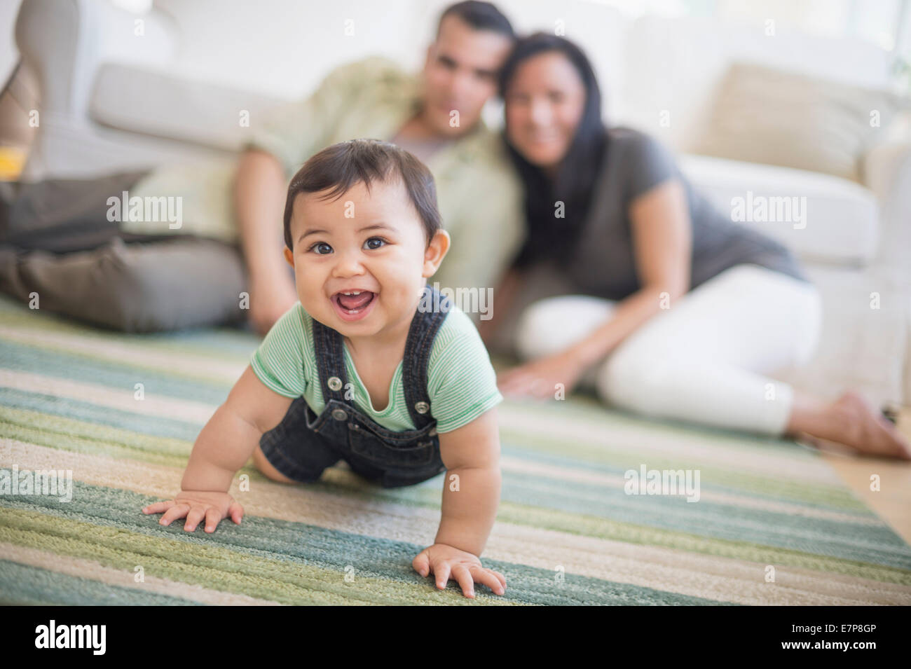 Famiglia con bambino figlio (6-11 mesi) nel soggiorno Foto Stock