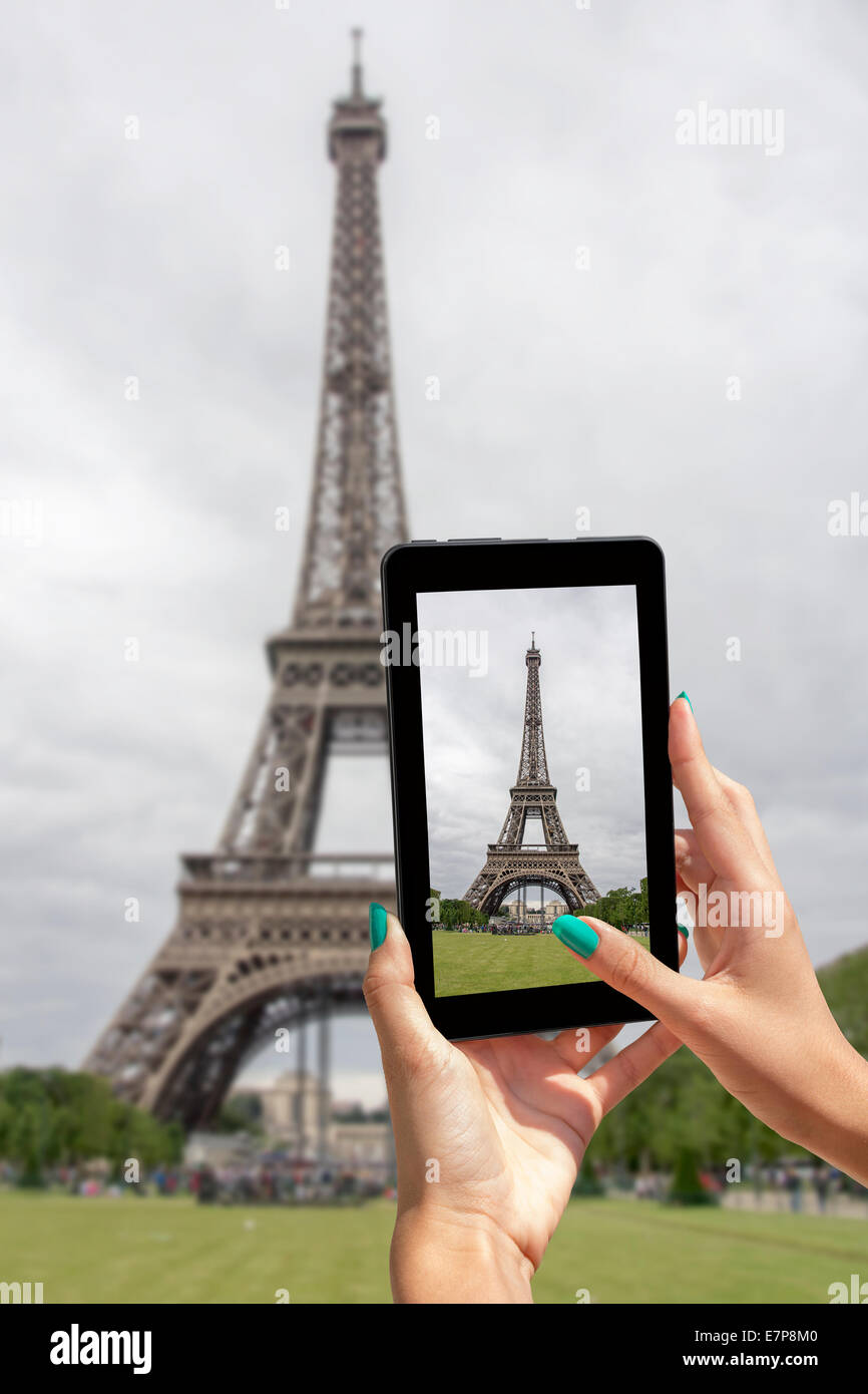 Giovane ragazza in viaggio e preso le immagini della Torre Eiffel, con la compressa Foto Stock
