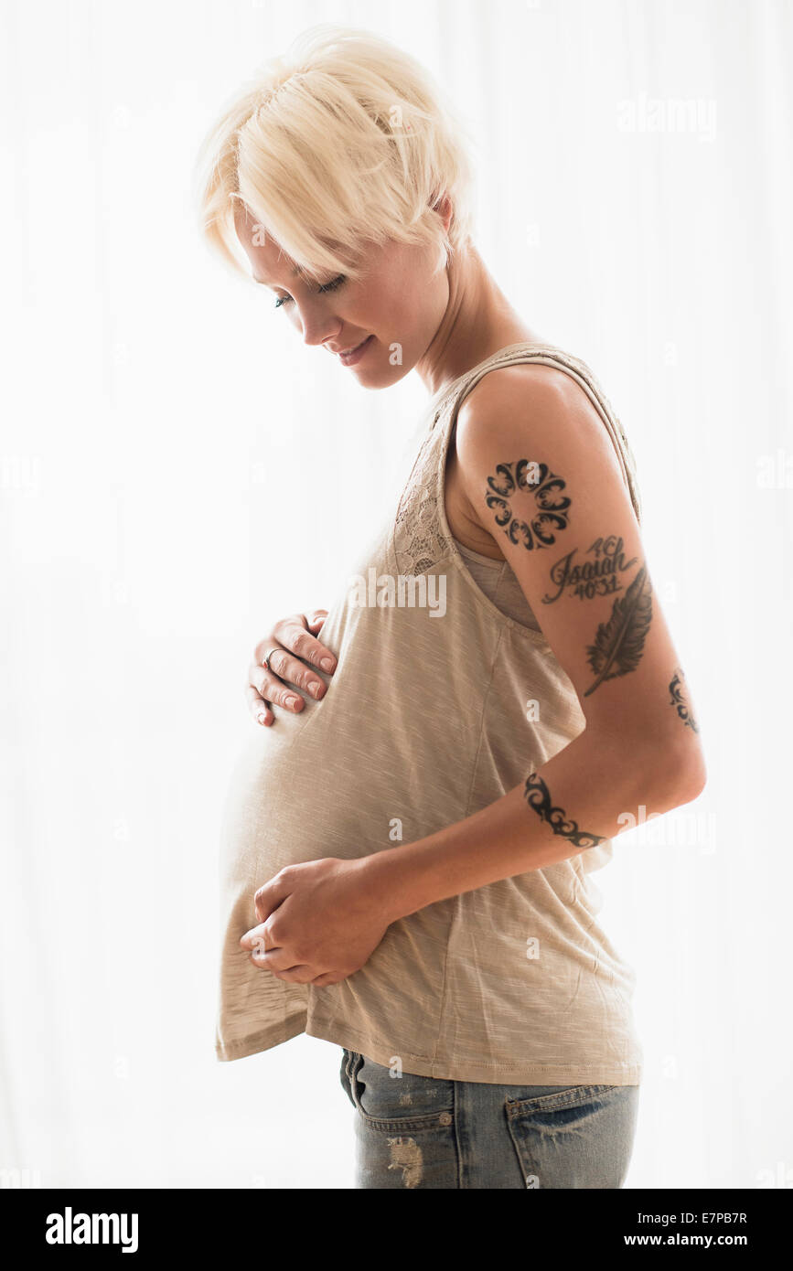 Donna incinta con le mani su stomaco Foto Stock