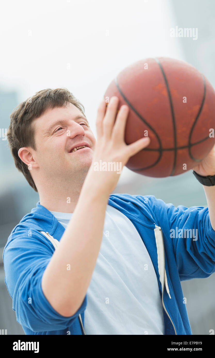 Uomo con la sindrome di down giocare a basket Foto Stock