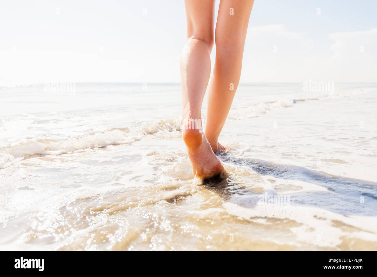 Gambe di donna passeggiate in mare Foto Stock