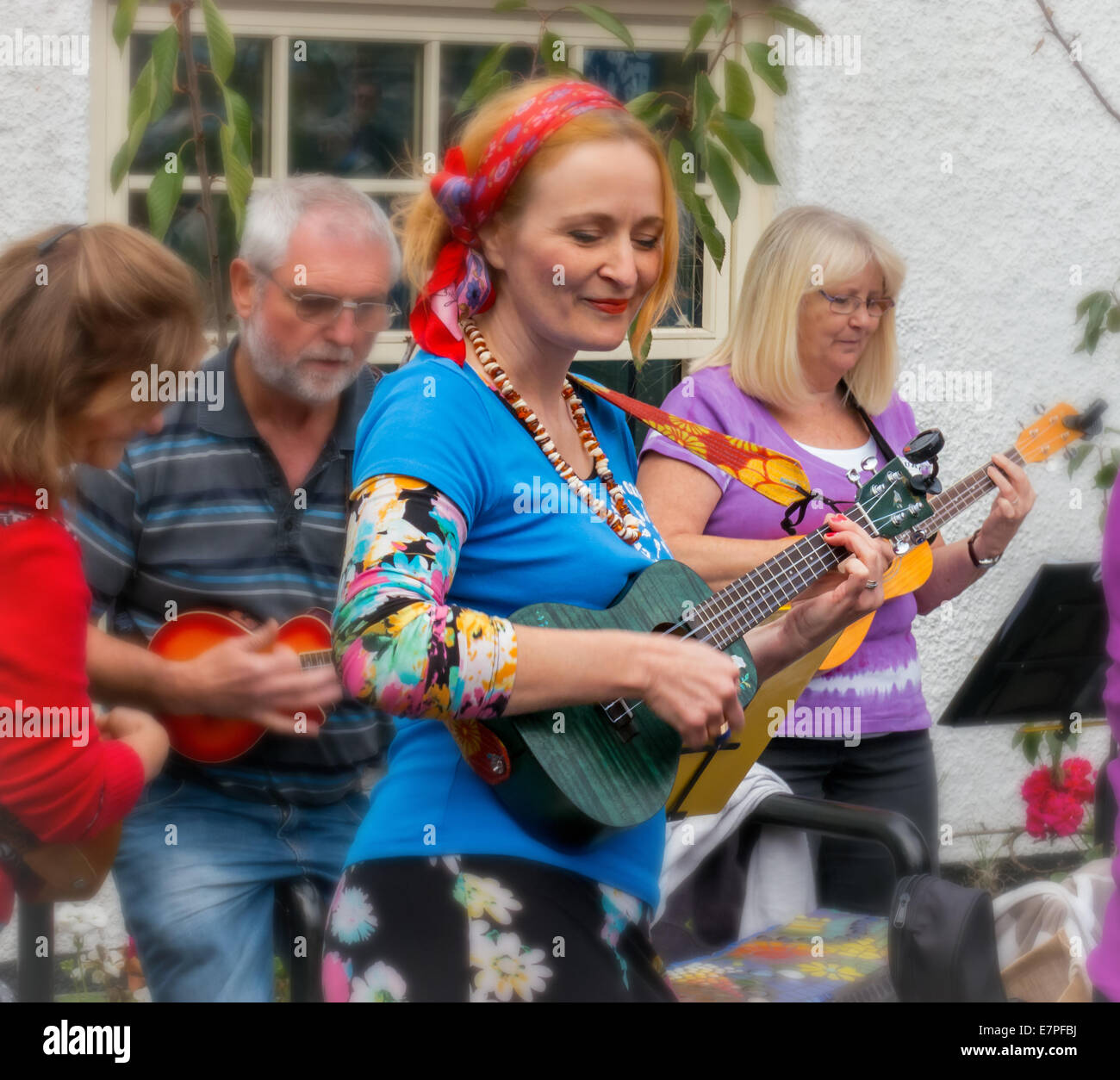 Lo stile di vita del Regno Unito: Colorful persona di sesso femminile in un ukulele orchestra band - che si diverte in un gruppo di musica Foto Stock Lo stile di vita del Regno Unito: Colorful persona di sesso femminile in un ukulele orchestra band - che si diverte in un gruppo di musica Foto Stock