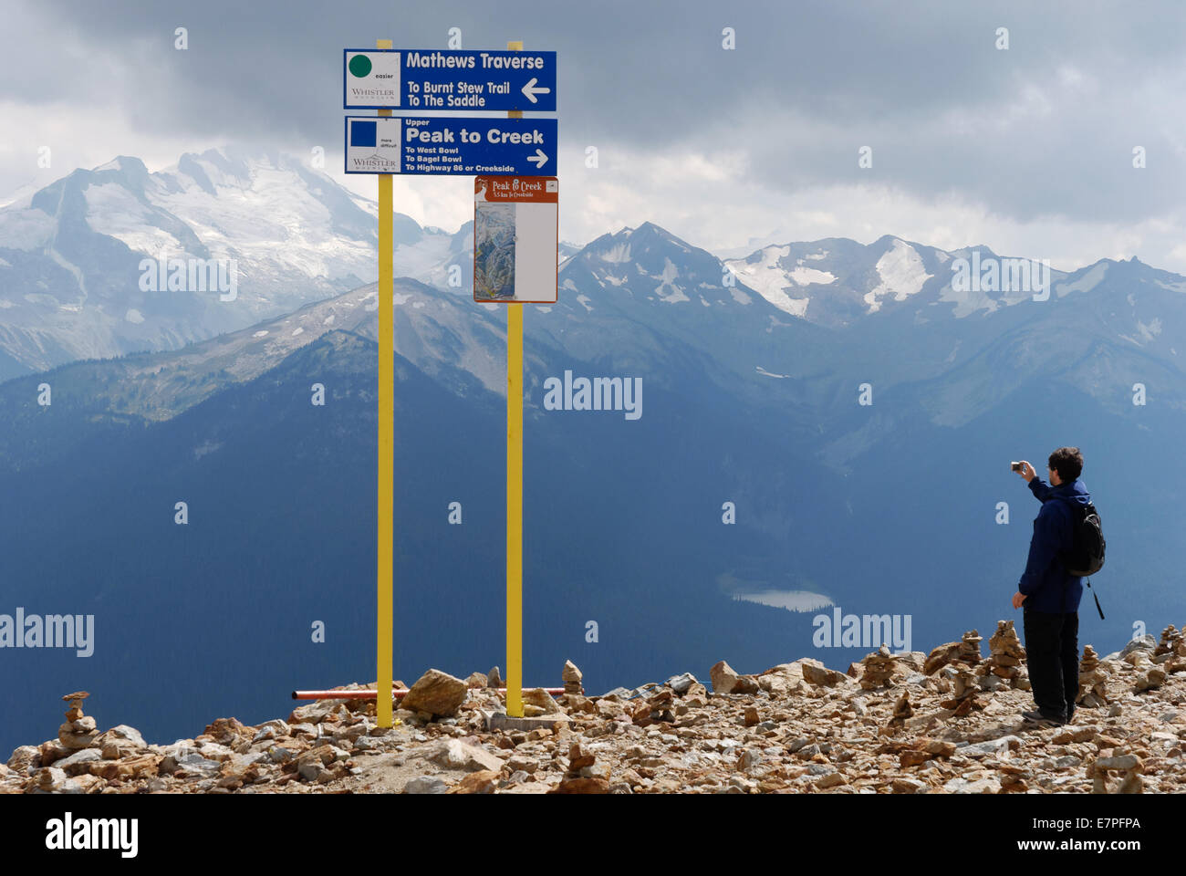 Un turista di scattare le foto picchi drammatici e la luce delle Montagne Rocciose a Whistler, British Columbia, Canada Foto Stock