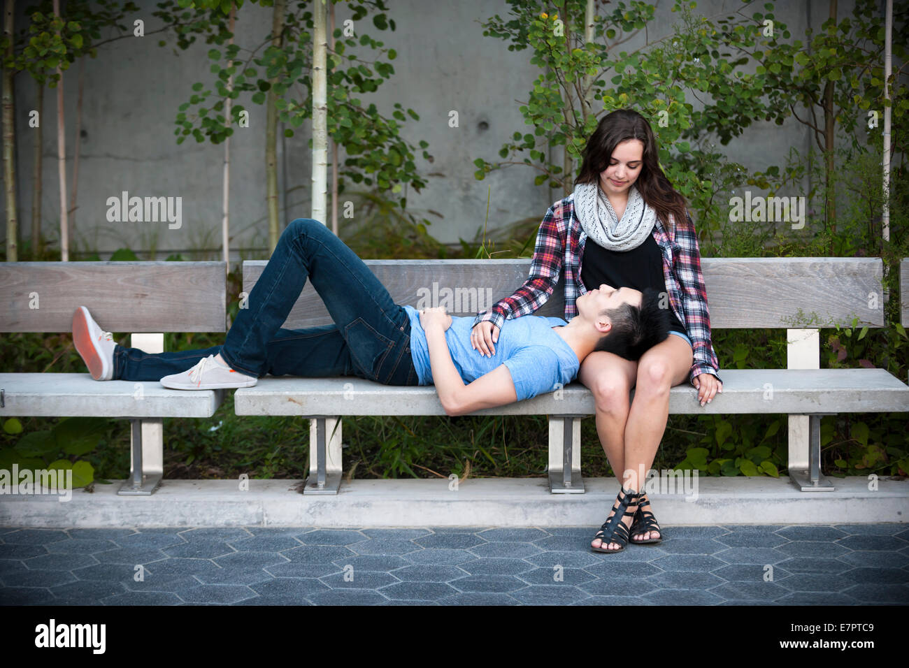 Romantico interracial coppia giovane relax su una panchina nel parco esterno Foto Stock