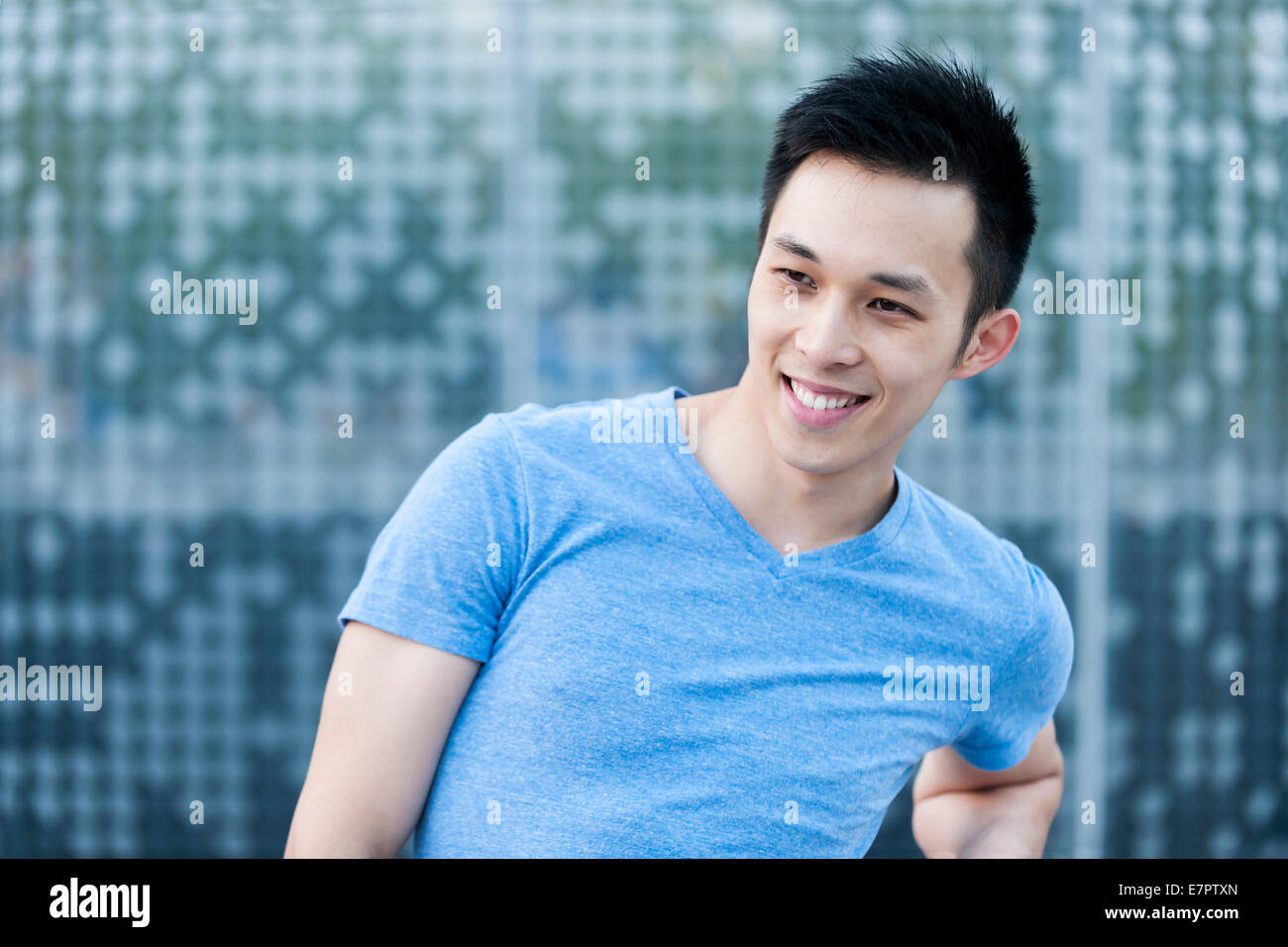 Ritratto di certi giovani asiatici uomo sorridente in ambiente urbano con spazio di copia Foto Stock