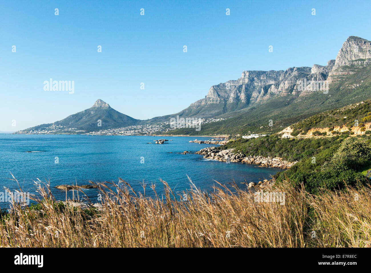 Oceano e la strada costiera a sud di Camps Bay, testa di leone e Table Mountain in background, Cape Town, Sud Africa Foto Stock