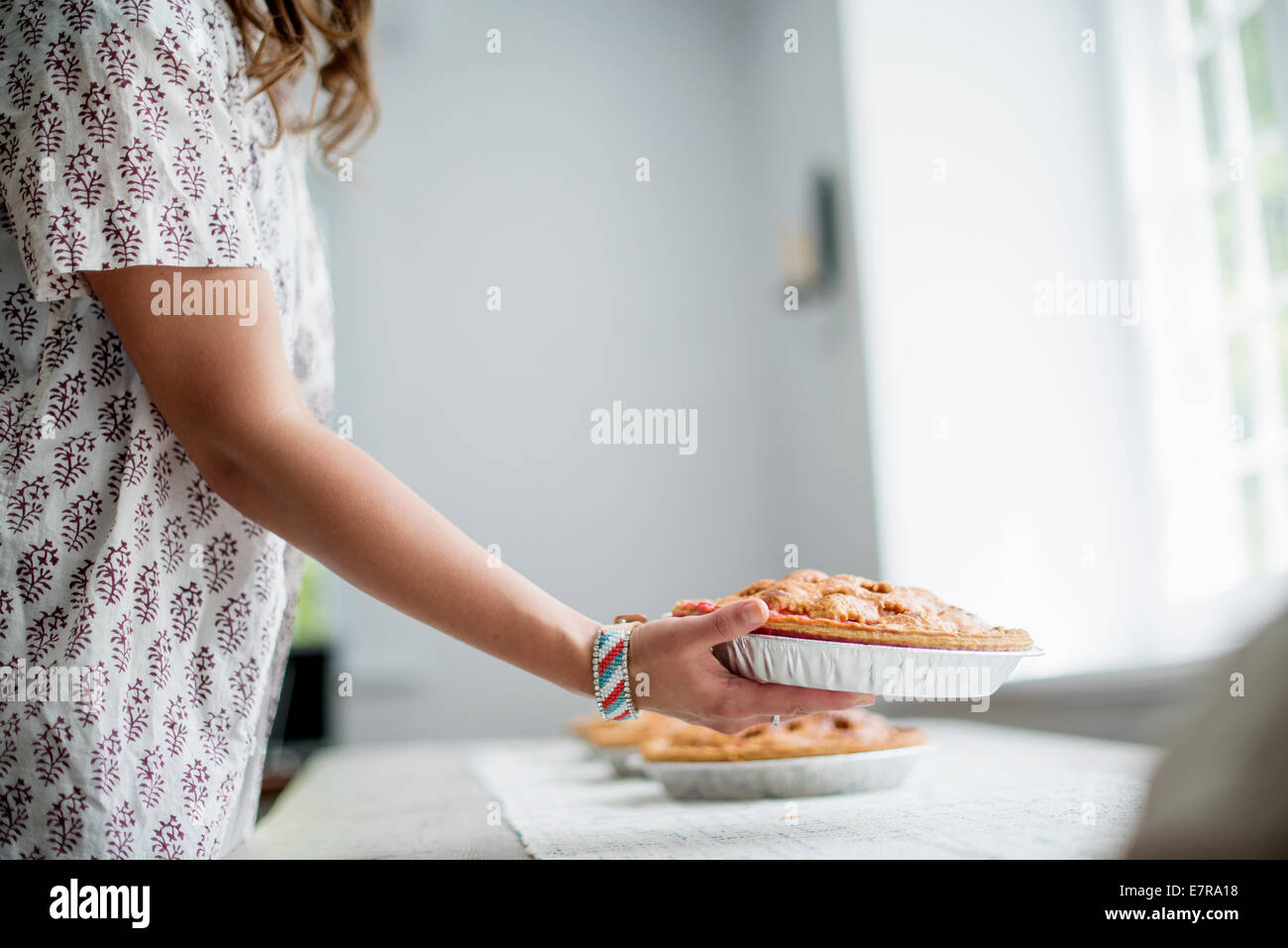 Una donna che trasportano derrate alimentari a una tabella, per preparare un pasto di famiglia. Foto Stock
