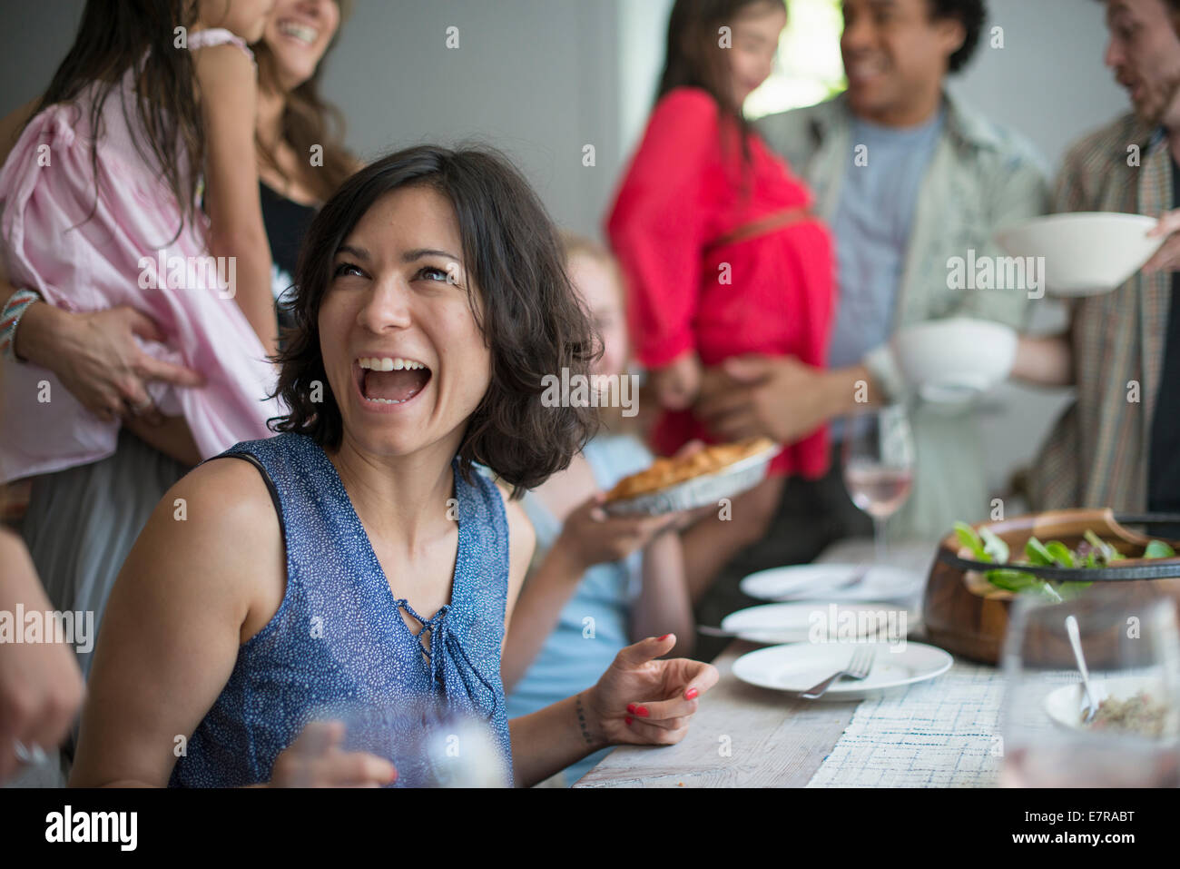 Una riunione di famiglia per un pasto. Adulti e bambini intorno a un tavolo. Foto Stock