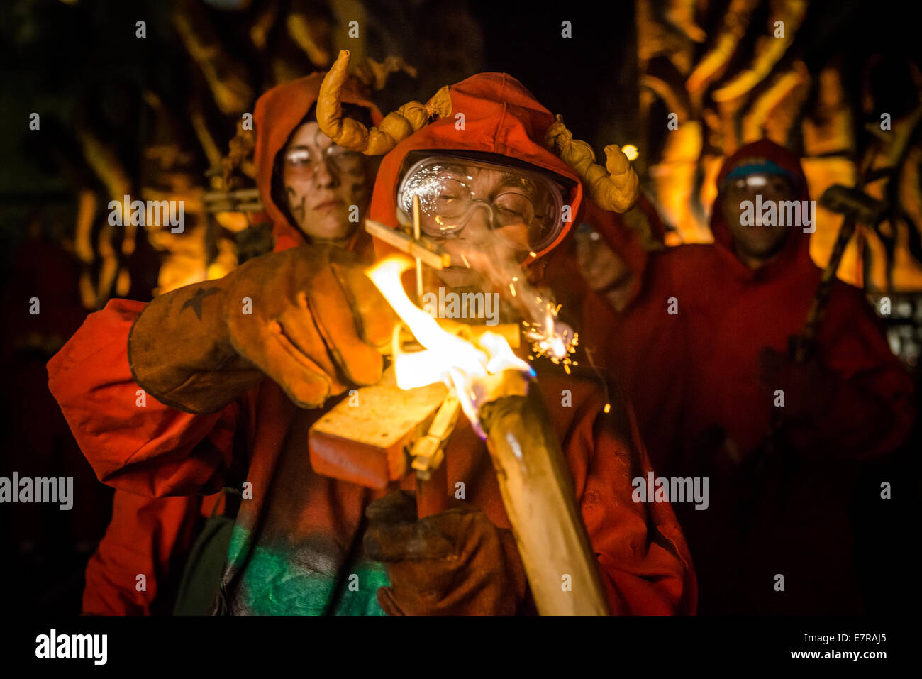 Barcellona, Spagna. Xxi Sep, 2014. Un diavolo il viso è illuminato come una torcia illumina la sua fire cracker durante la merce 2014 Credit: matthi/Alamy Live News Foto Stock