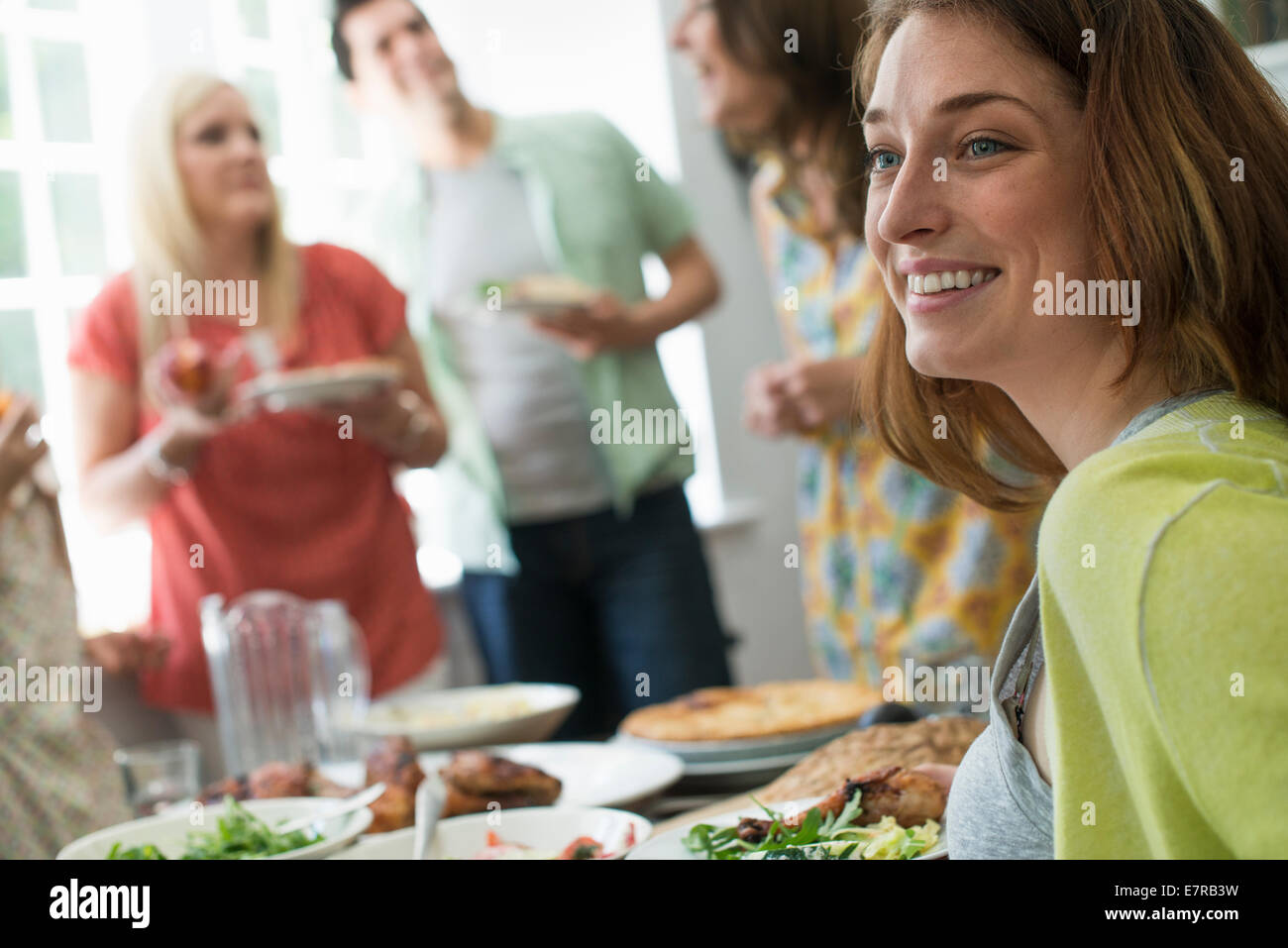Una riunione di famiglia per un pasto. Adulti e bambini intorno a un tavolo. Foto Stock