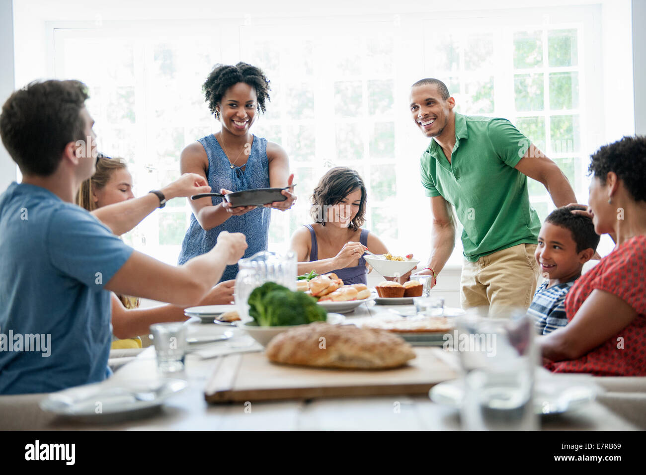 Una riunione di famiglia per un pasto. Adulti e bambini intorno a un tavolo. Foto Stock